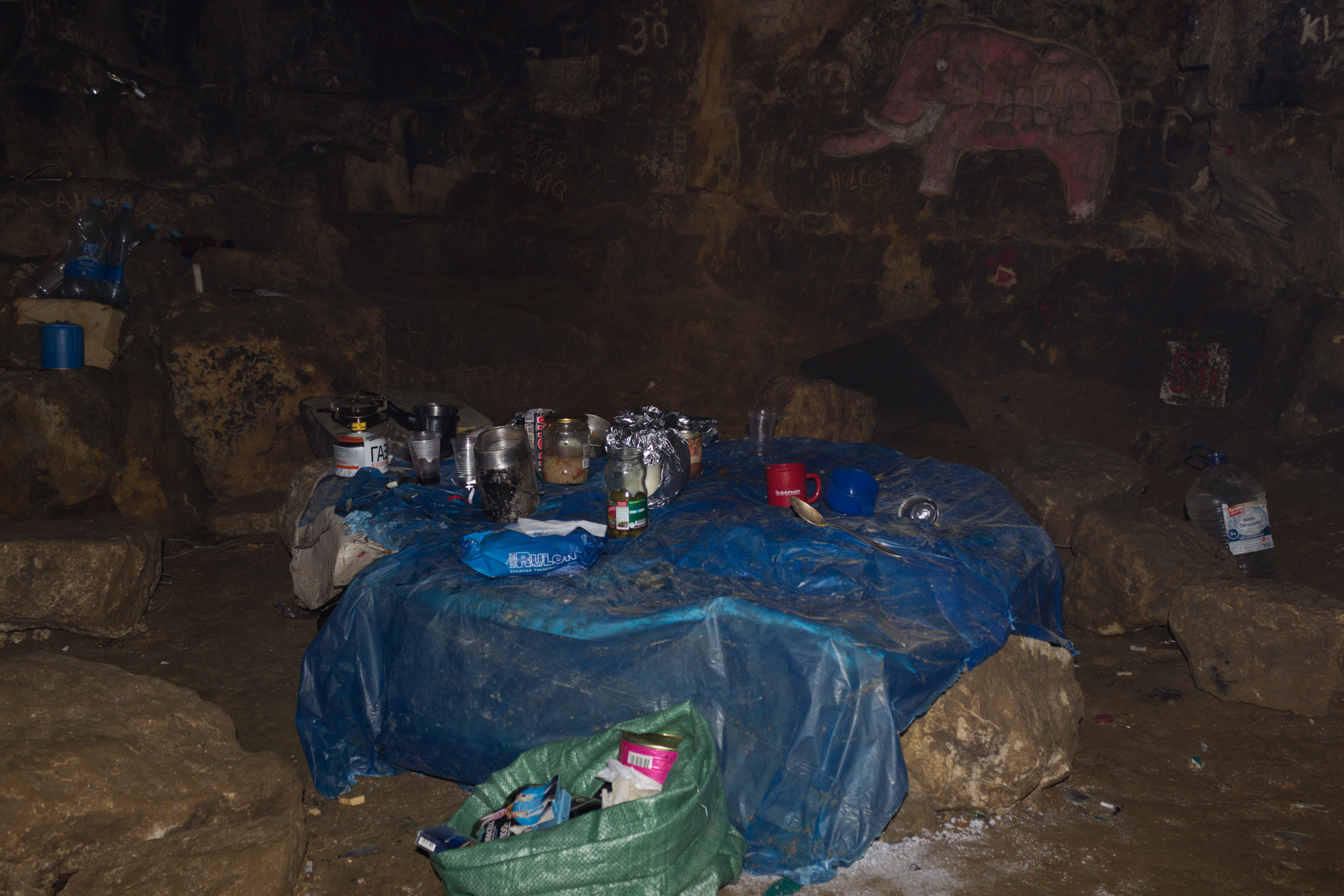 Грот в Киселях. На столах, в упаковках, которые защищают от грызунов, оставляют продукты с длительным сроком хранения. Все, что могут съесть мыши и крысы, подвешивают к потолку. Мусор собирают в пакеты и выносят на поверхность. Раз в год энтузиасты проводят под землей субботники.