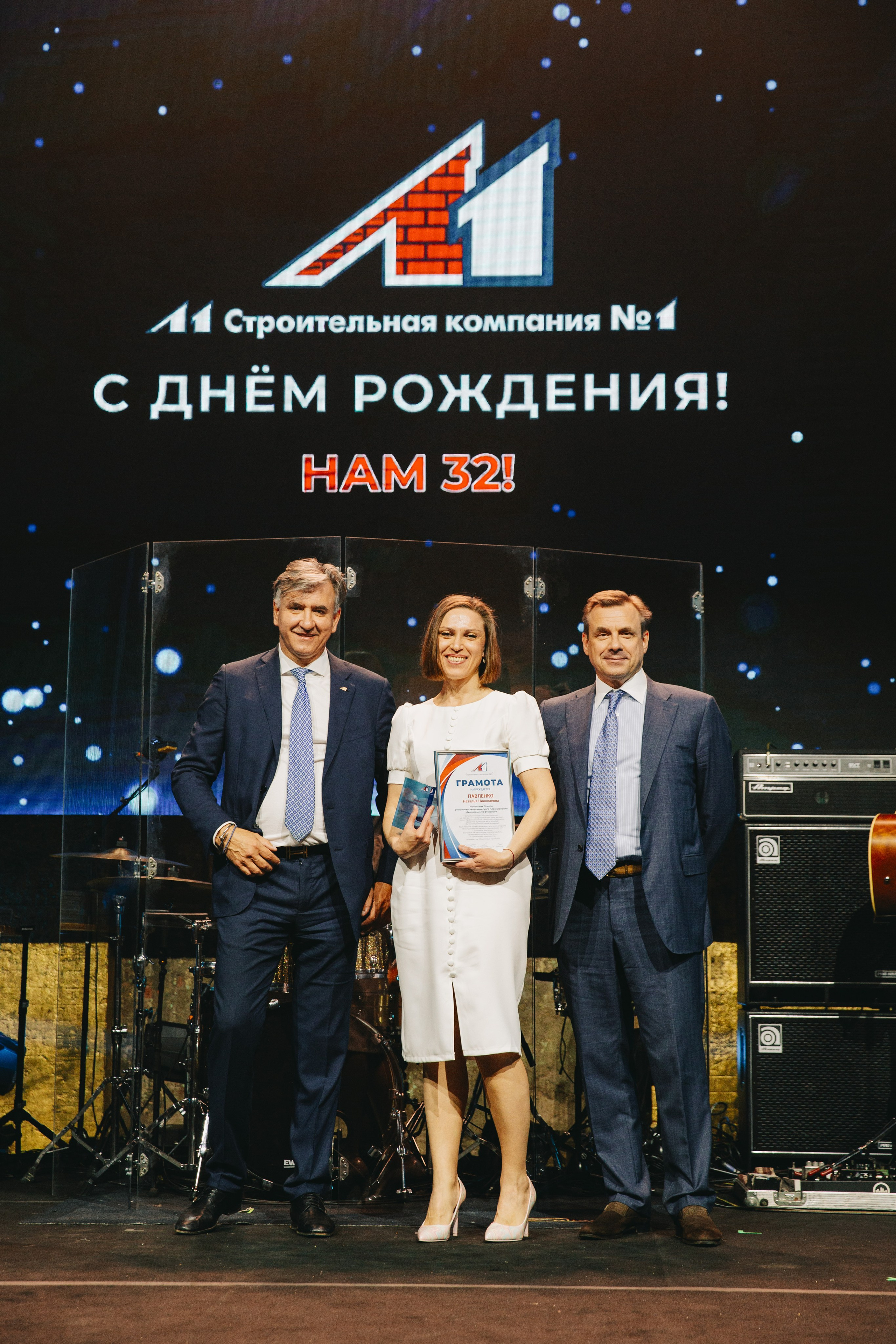 Два генеральных директора поздравляют сотрудника на сцене Loft Hall
