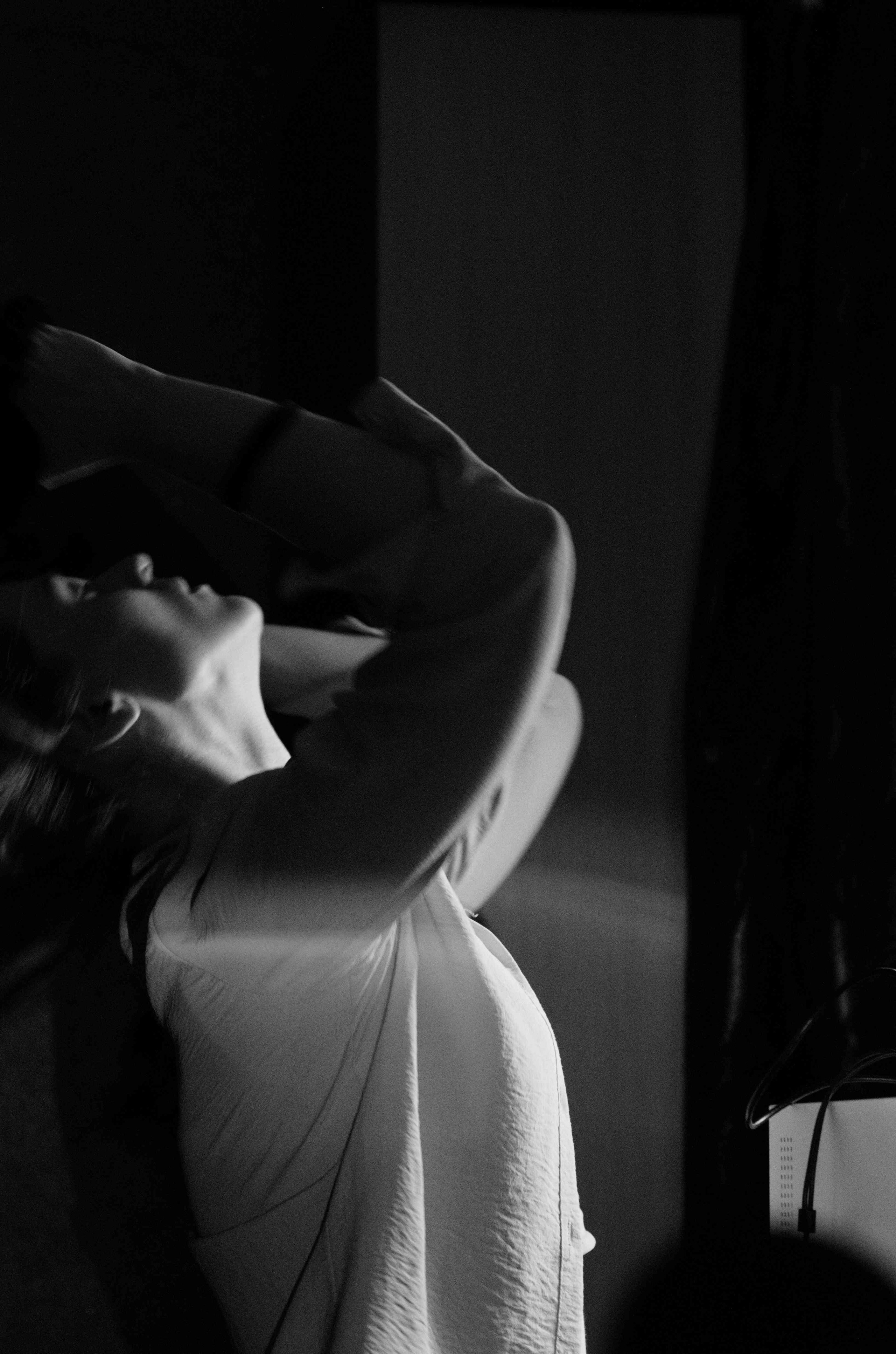 Девушка в профиль запрокинула голову, чтобы собрать волосы