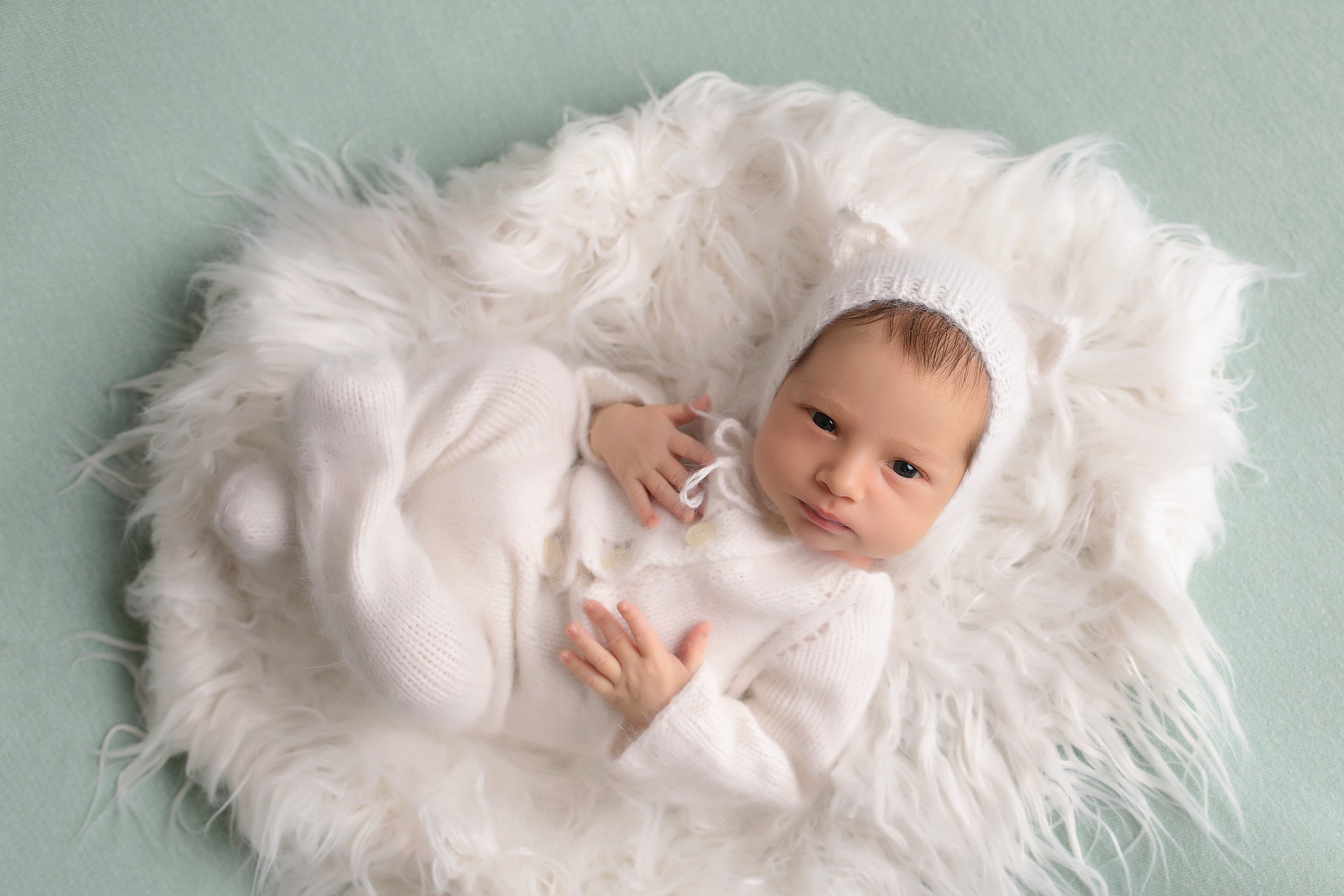 фото новорожденного в белом костюме на пушистом коврике