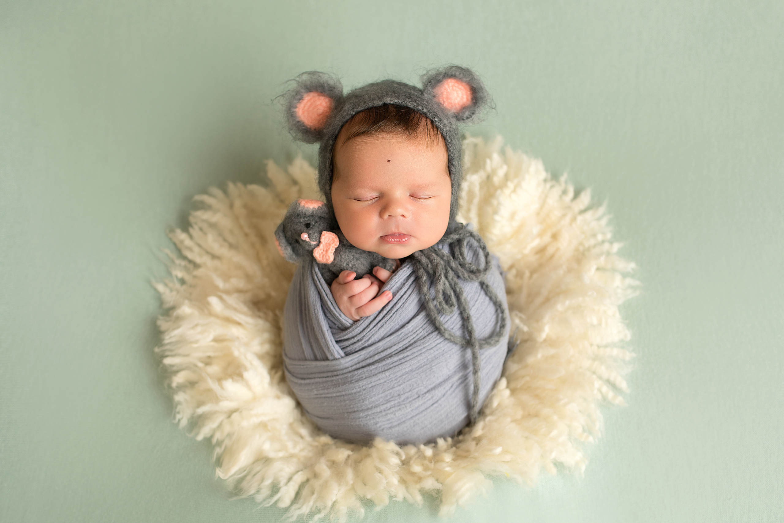 новорожденный малыш в обмотке в костюме мышки с мышонком на пушистом коврике