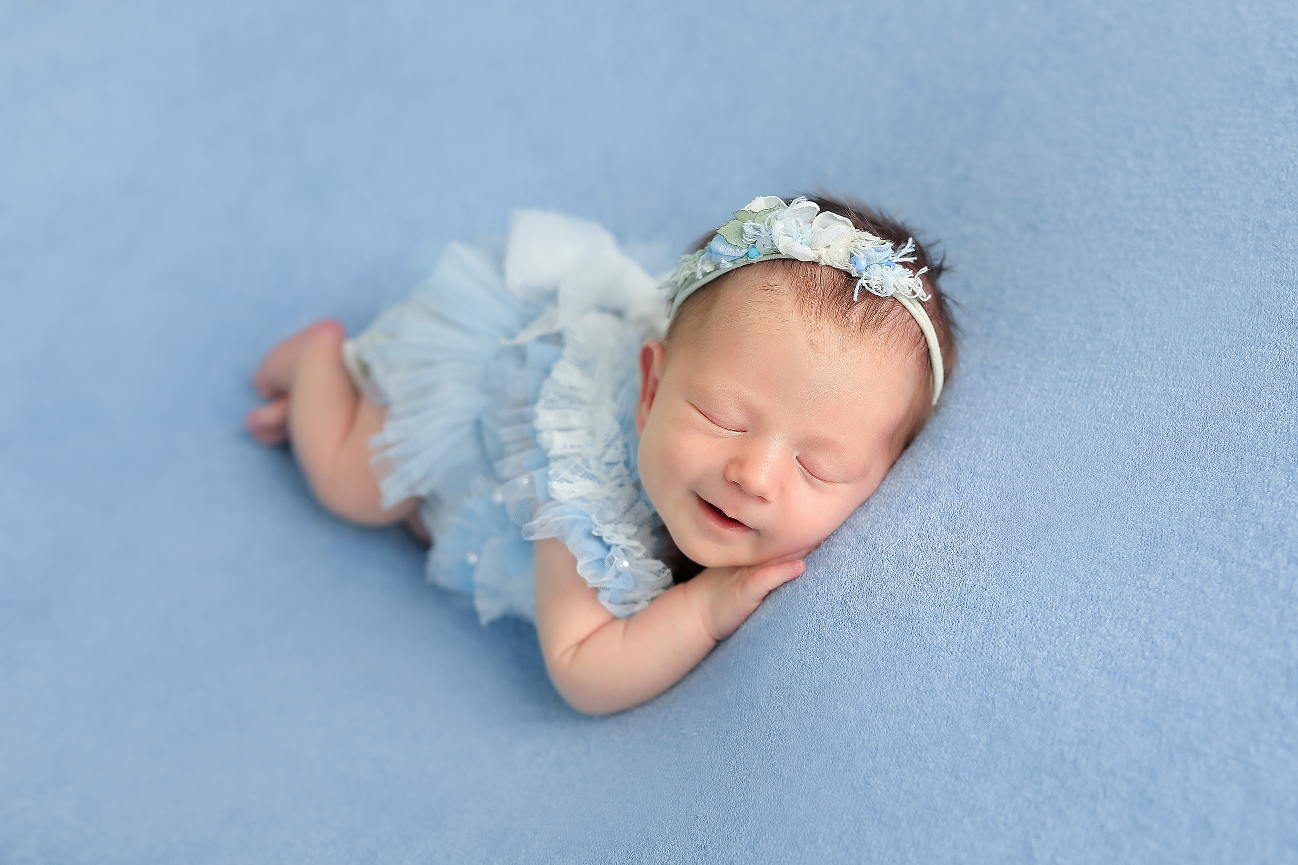 фото девочки новорожденной в голубом с ручками под щечкой