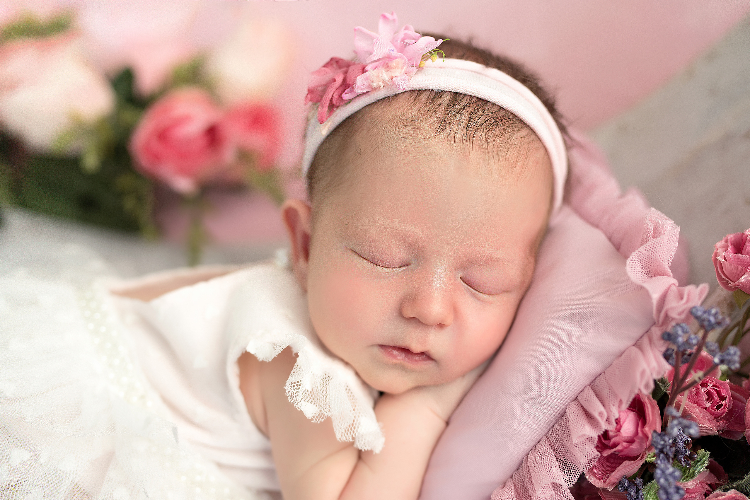 портрет новорожденной девочки на розовой подушке
