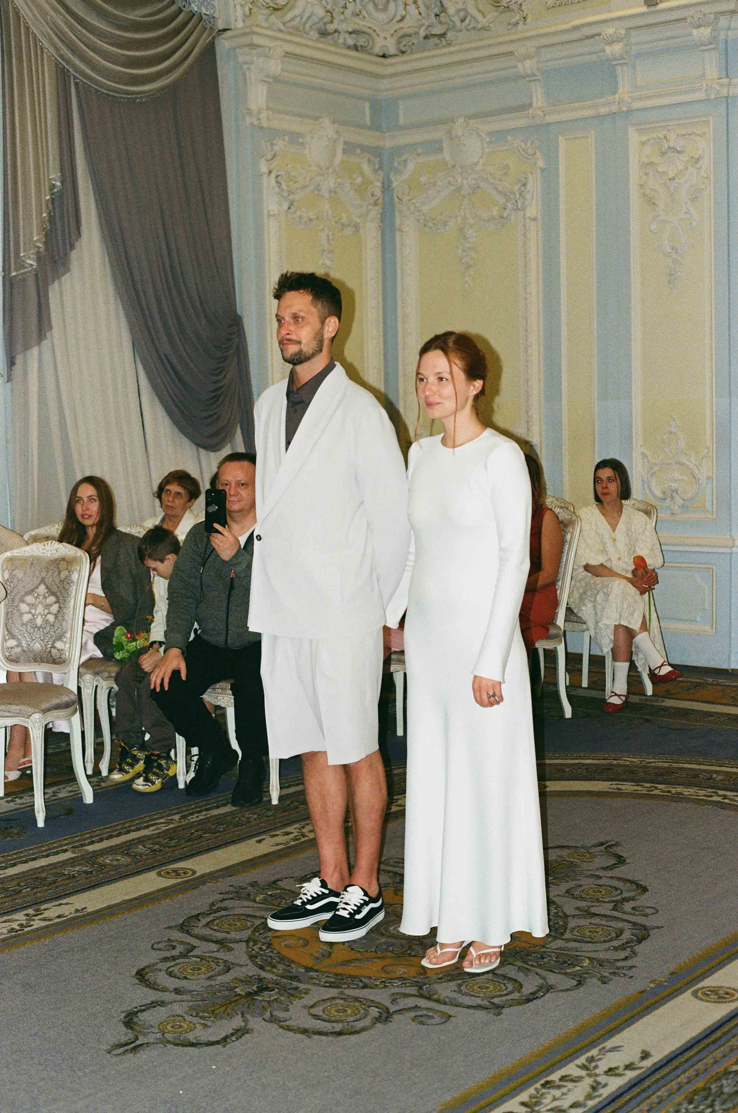 Плёночное фото: жених и невеста стоят в роскошном ЗАГСе во время церемонии