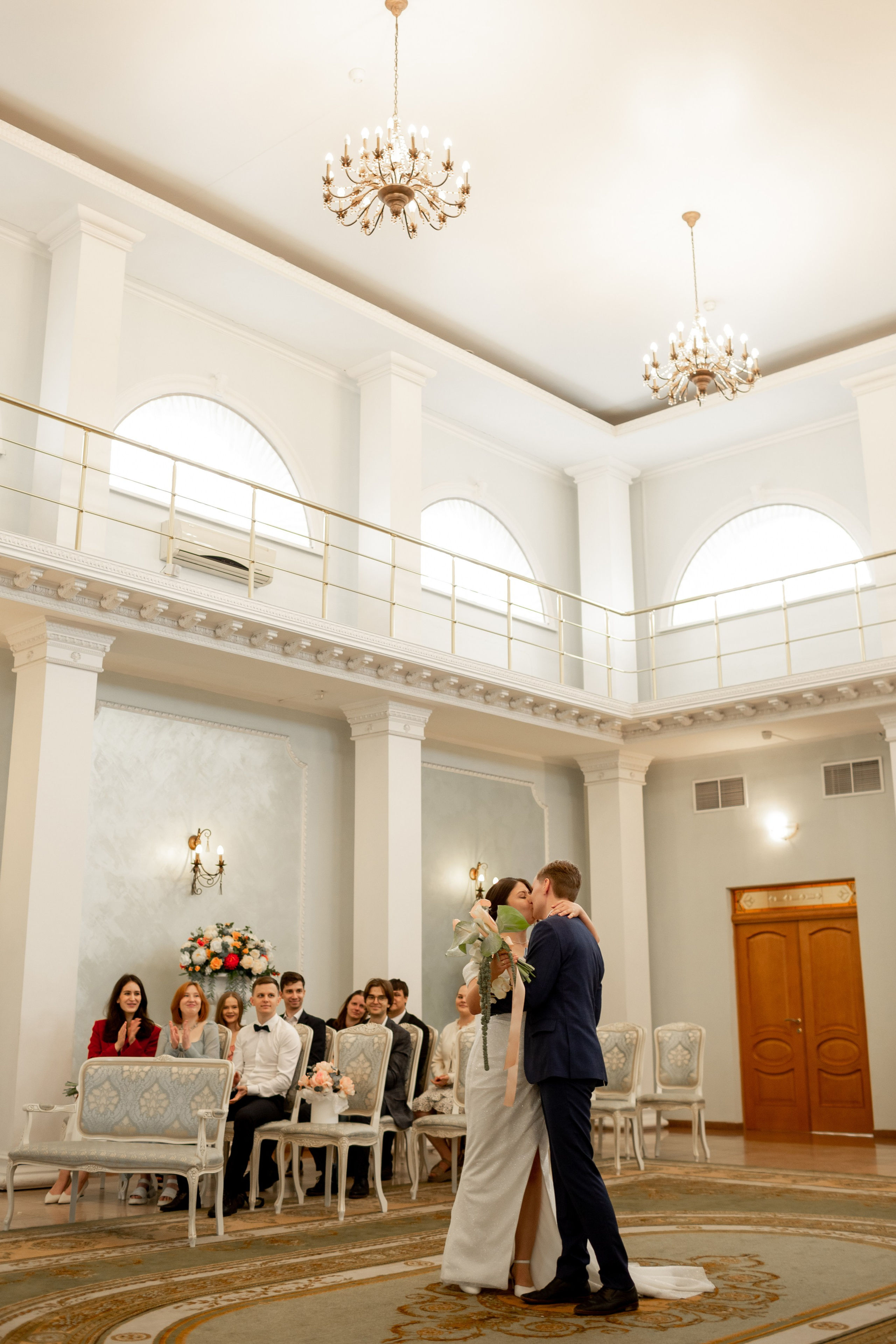 Жених и невеста целуют друг друга на церемонии торжественной регистрации брака.