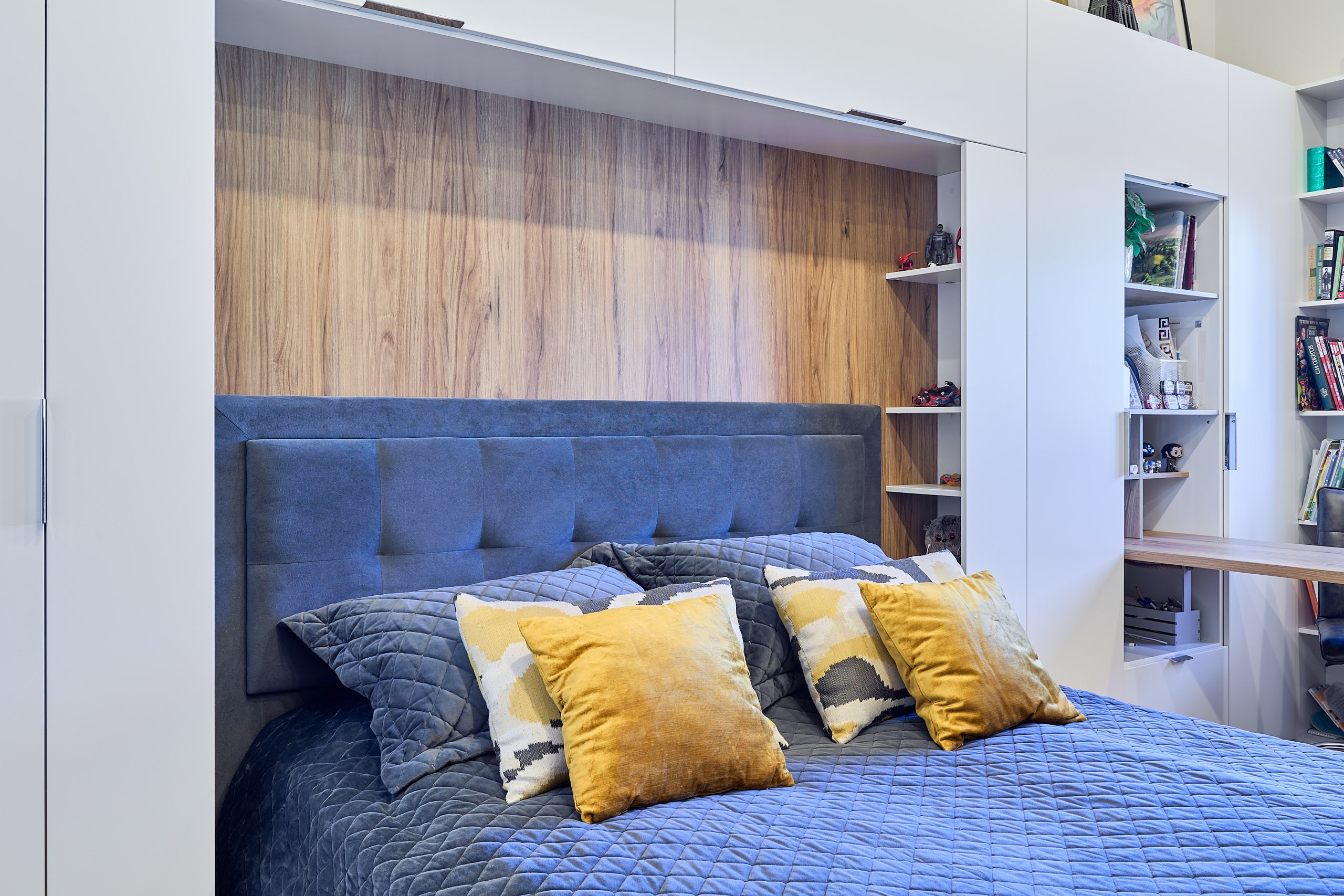 Интерьерная фотография с подушками на синей кровати