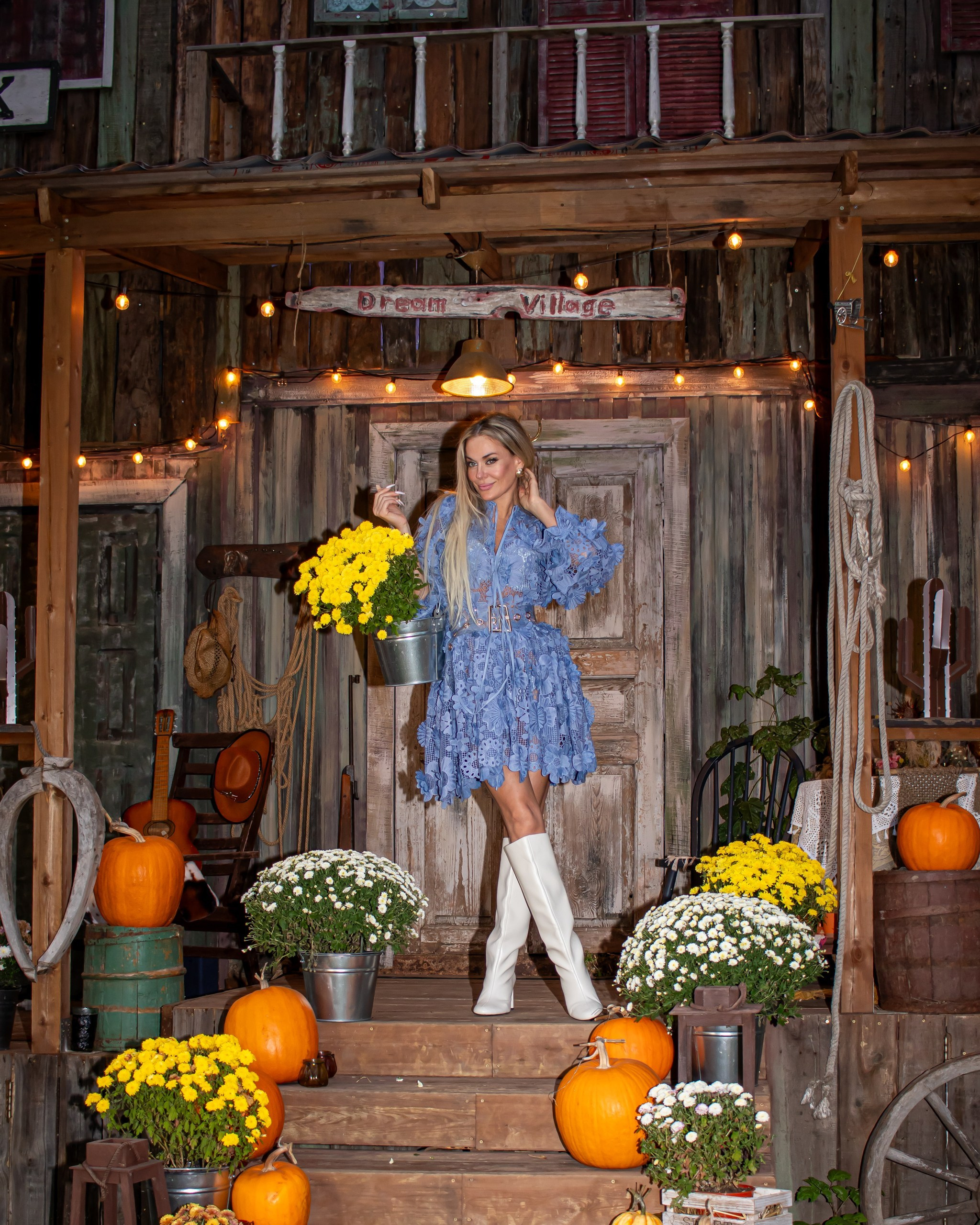 Женщина позирует у деревянного дома с осенним декором — фотосессия, фотограф Карасёва Елена