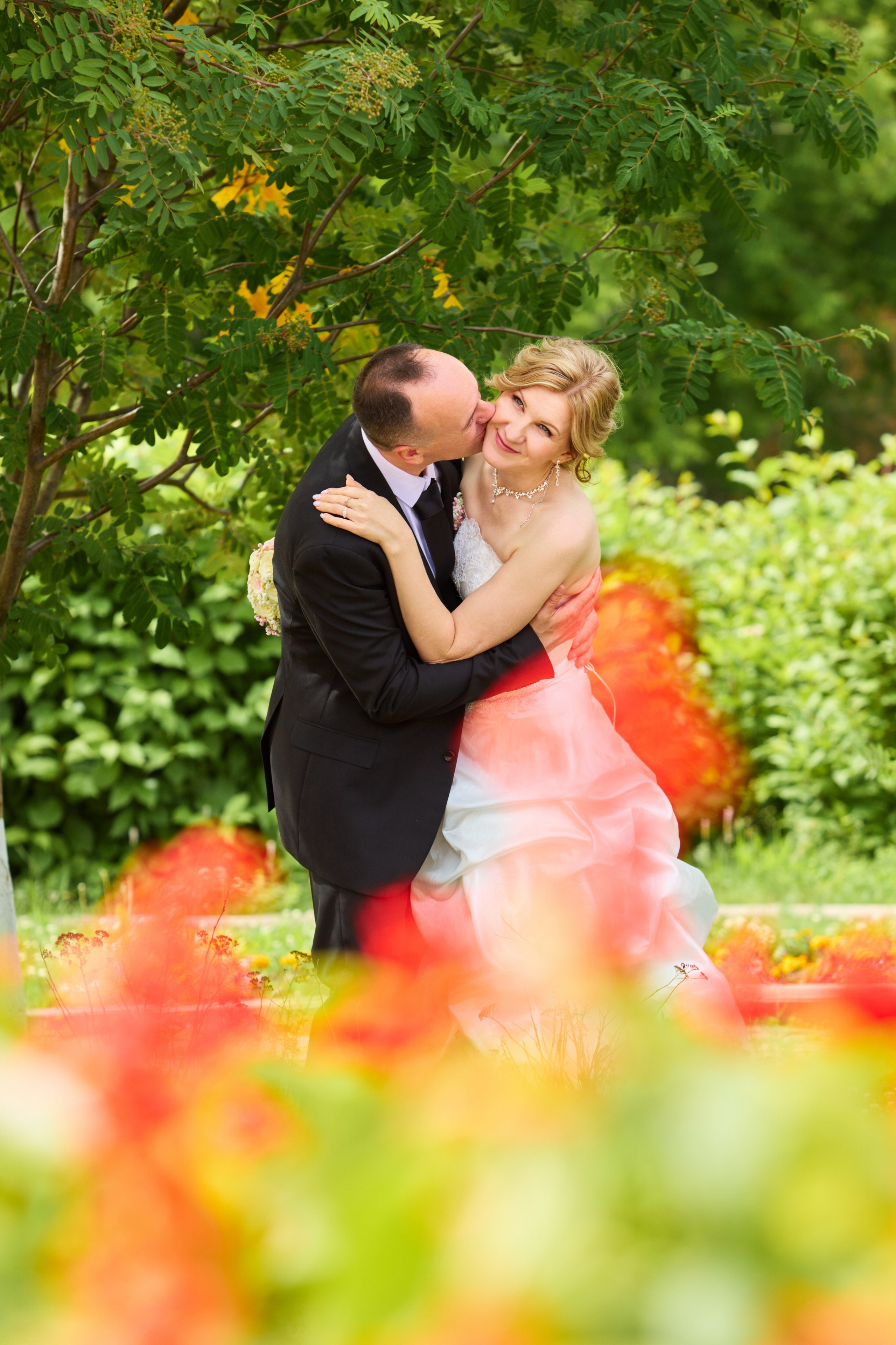 жених и невеста на фоне желто красных цветов в размытии