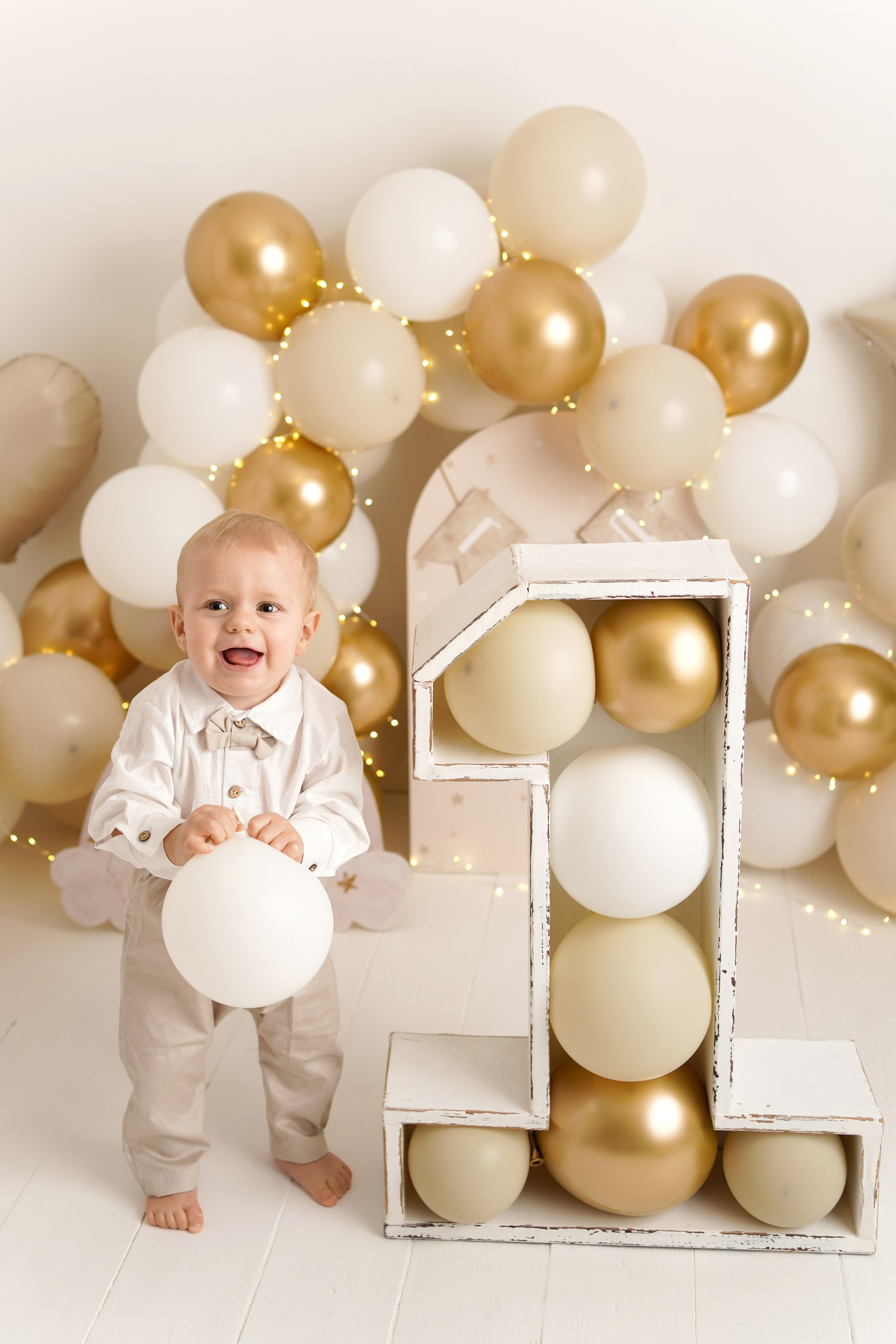 Малыш стоит рядом с огромной единицей, потому что ему сегодня исполняется один год