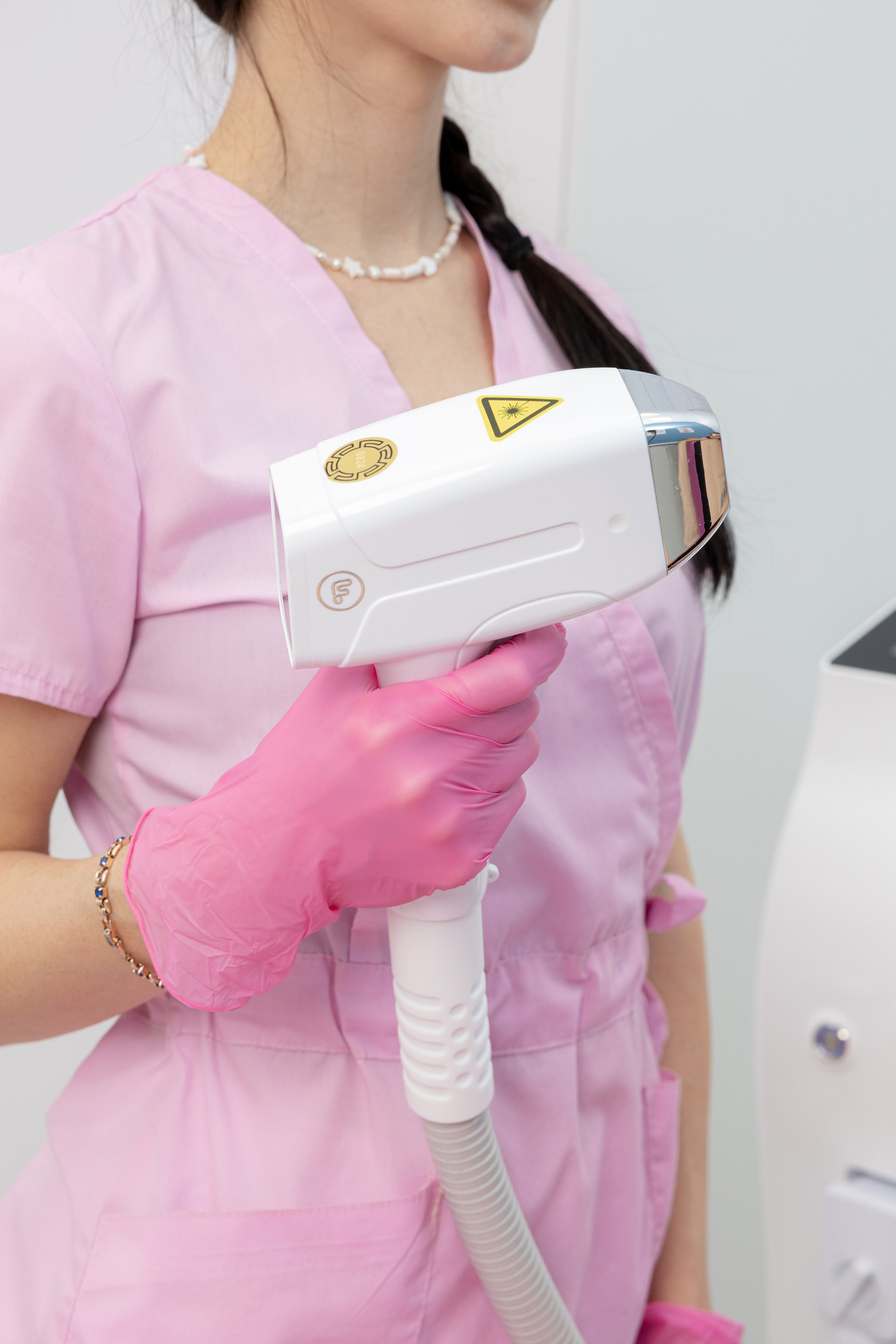 Девушка держит в руке прибор для лазерной эпиляции