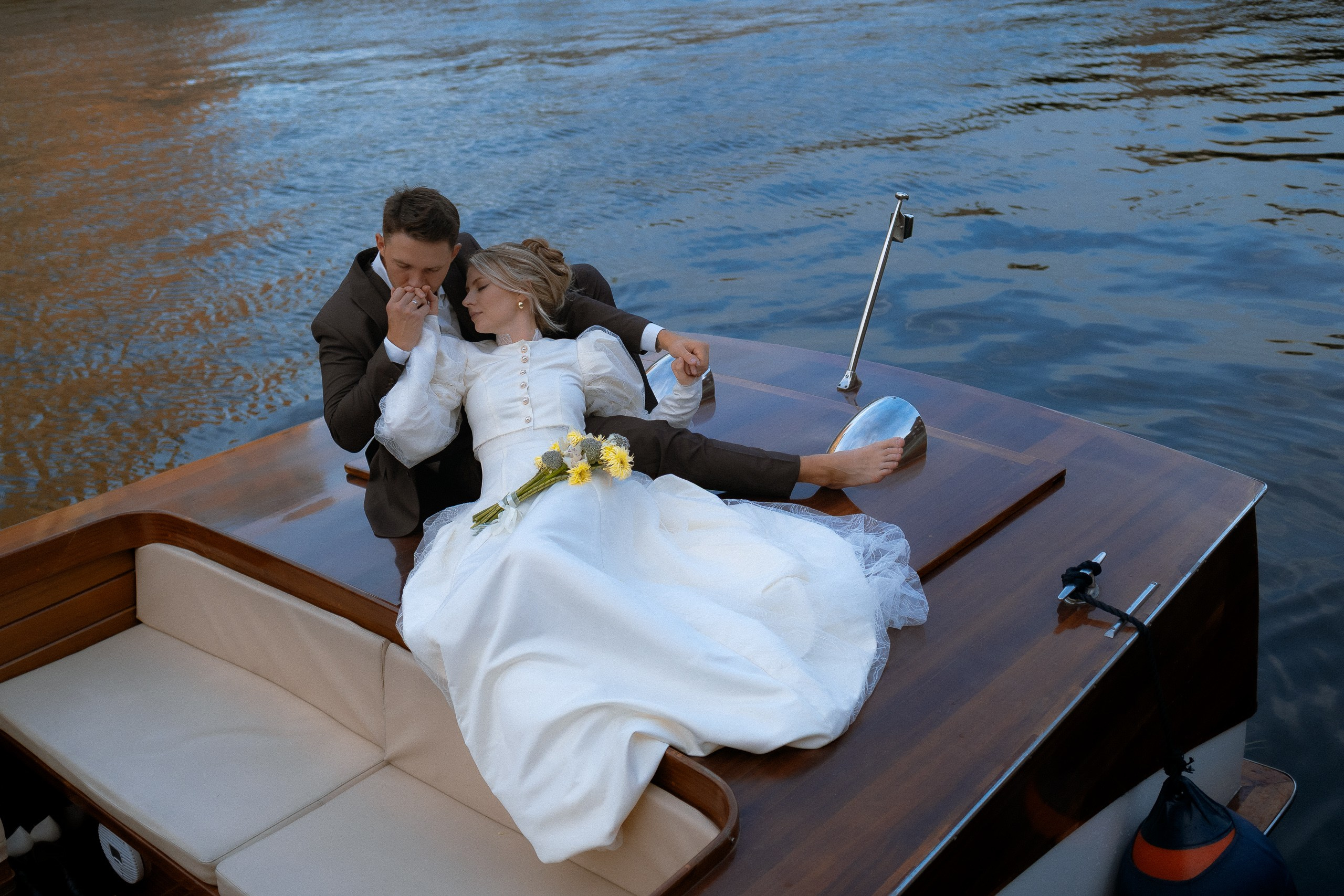 Поцелуй на корме катера — романтический кадр во время свадебной прогулки