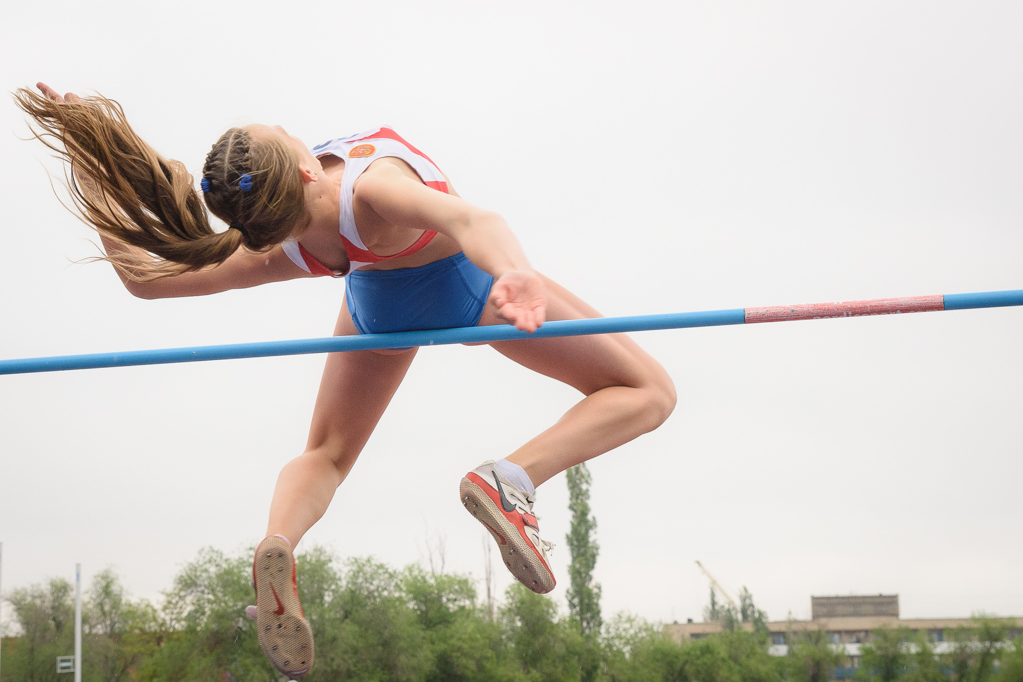 Спортсменка совершает прыжок в высоту