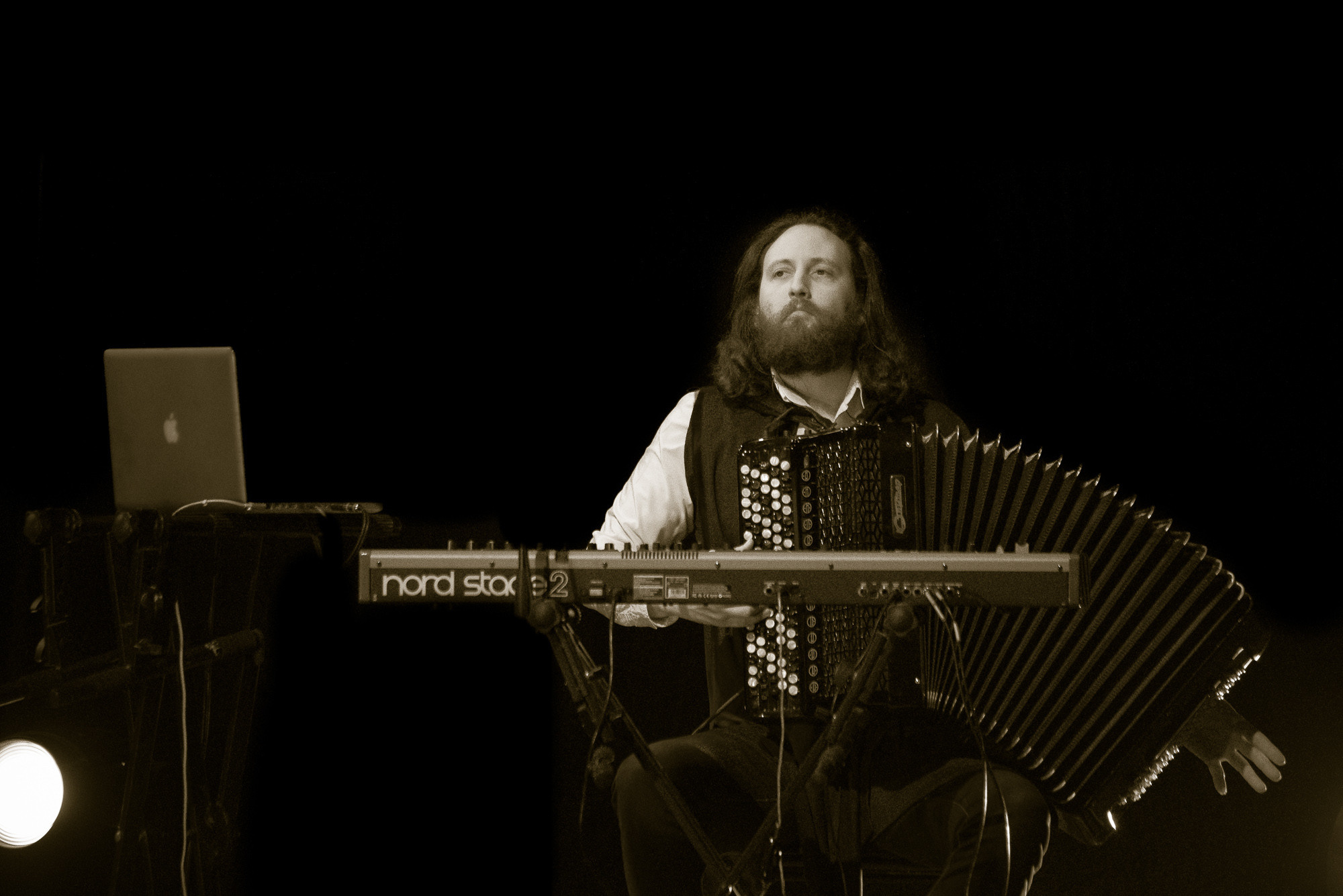 Участник группы "Пелагея" Антон Цыпкин сидит с баяном