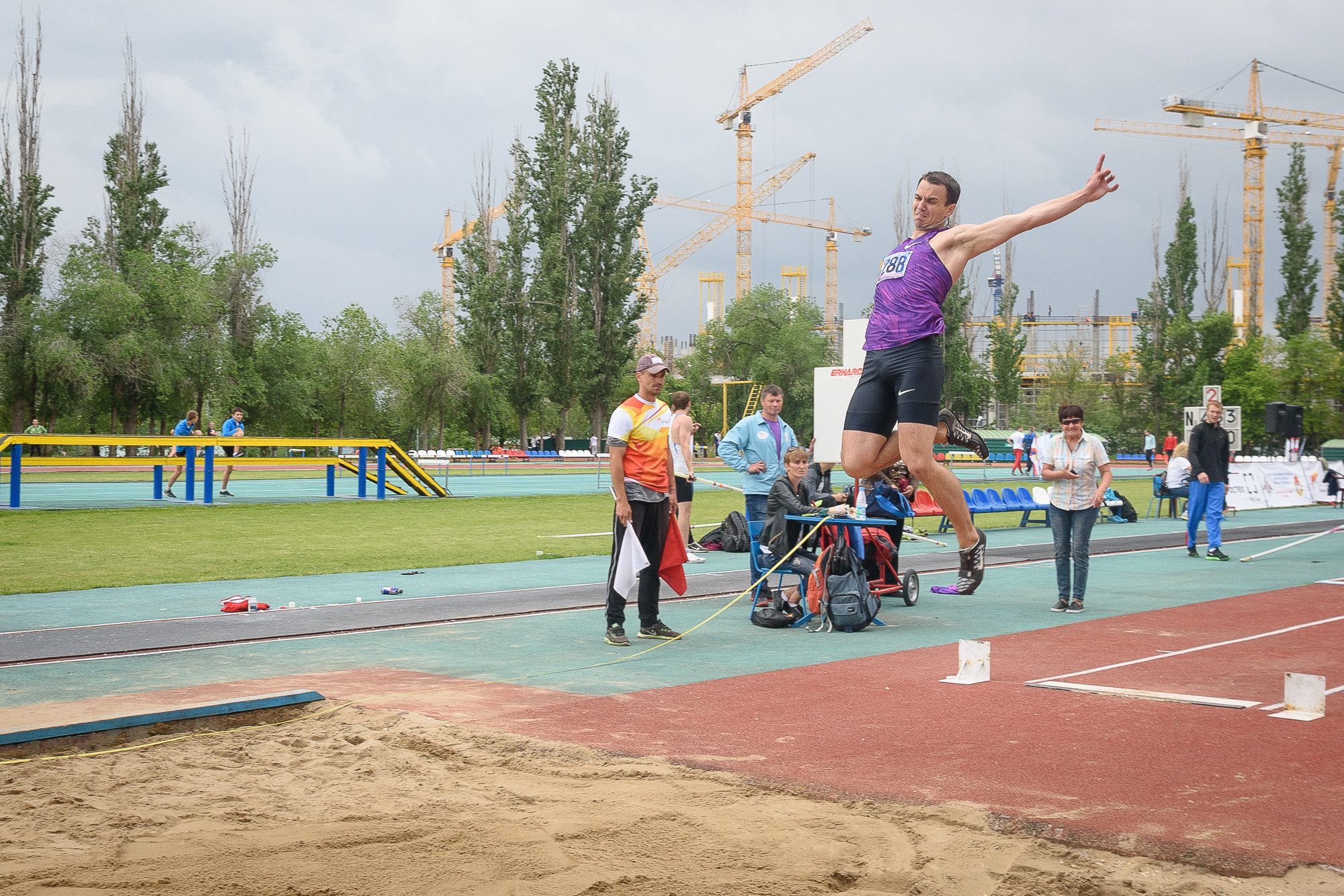 Спортсмен в полете при совершении тройного прыжка