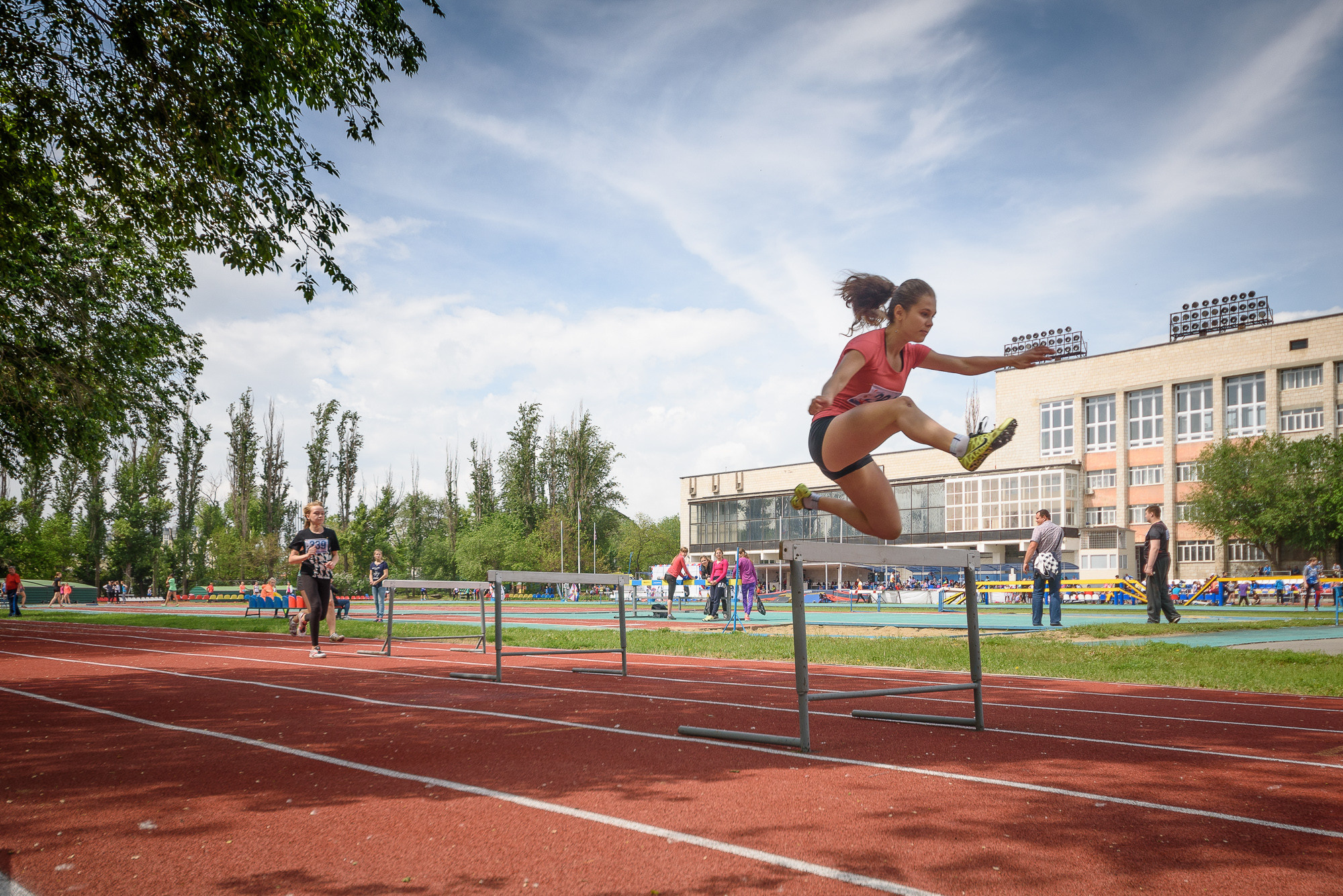 Бегунья в полете во время прыжка через барьер