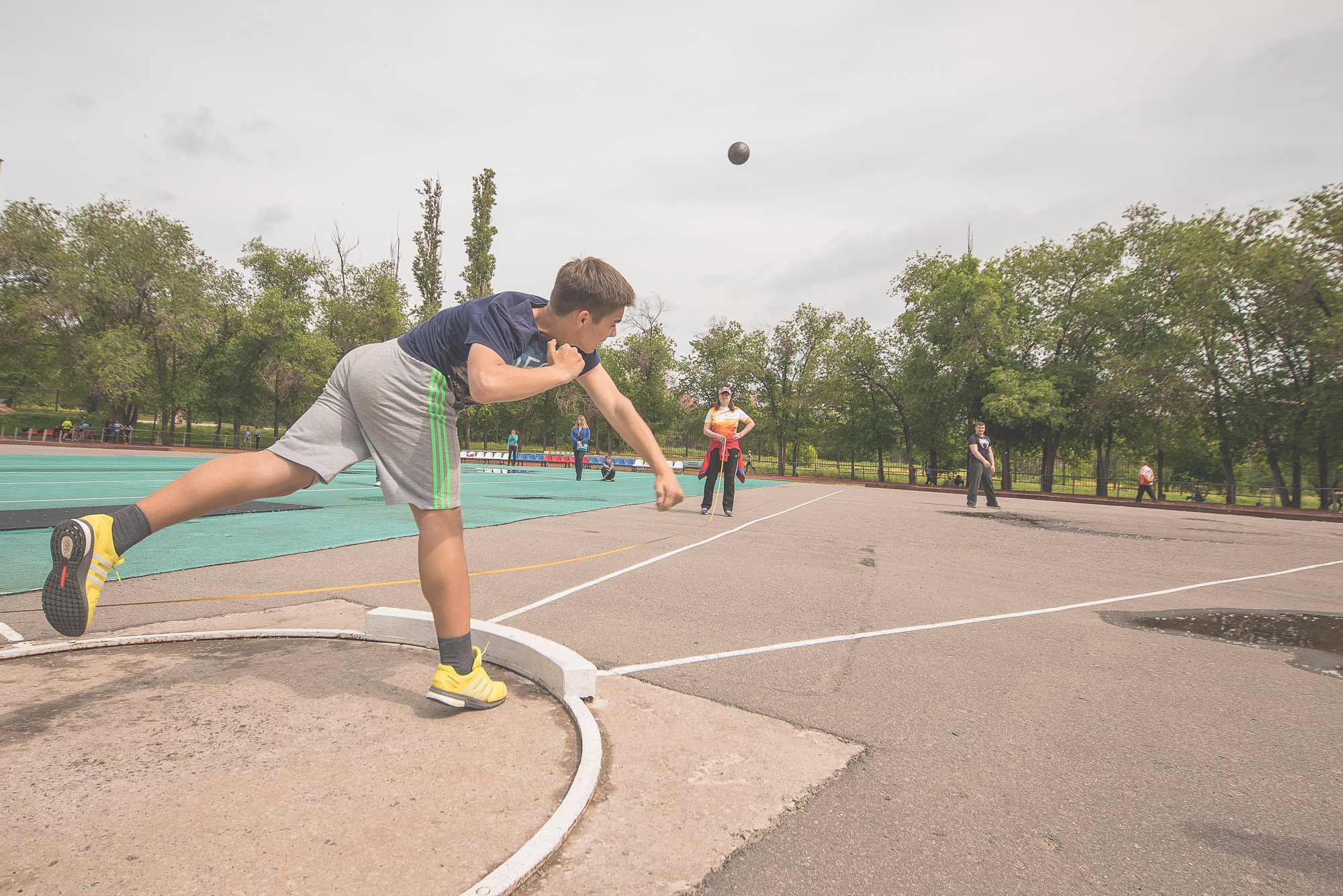 Спортсмен толкает ядро на легкоатлетических соревнованиях