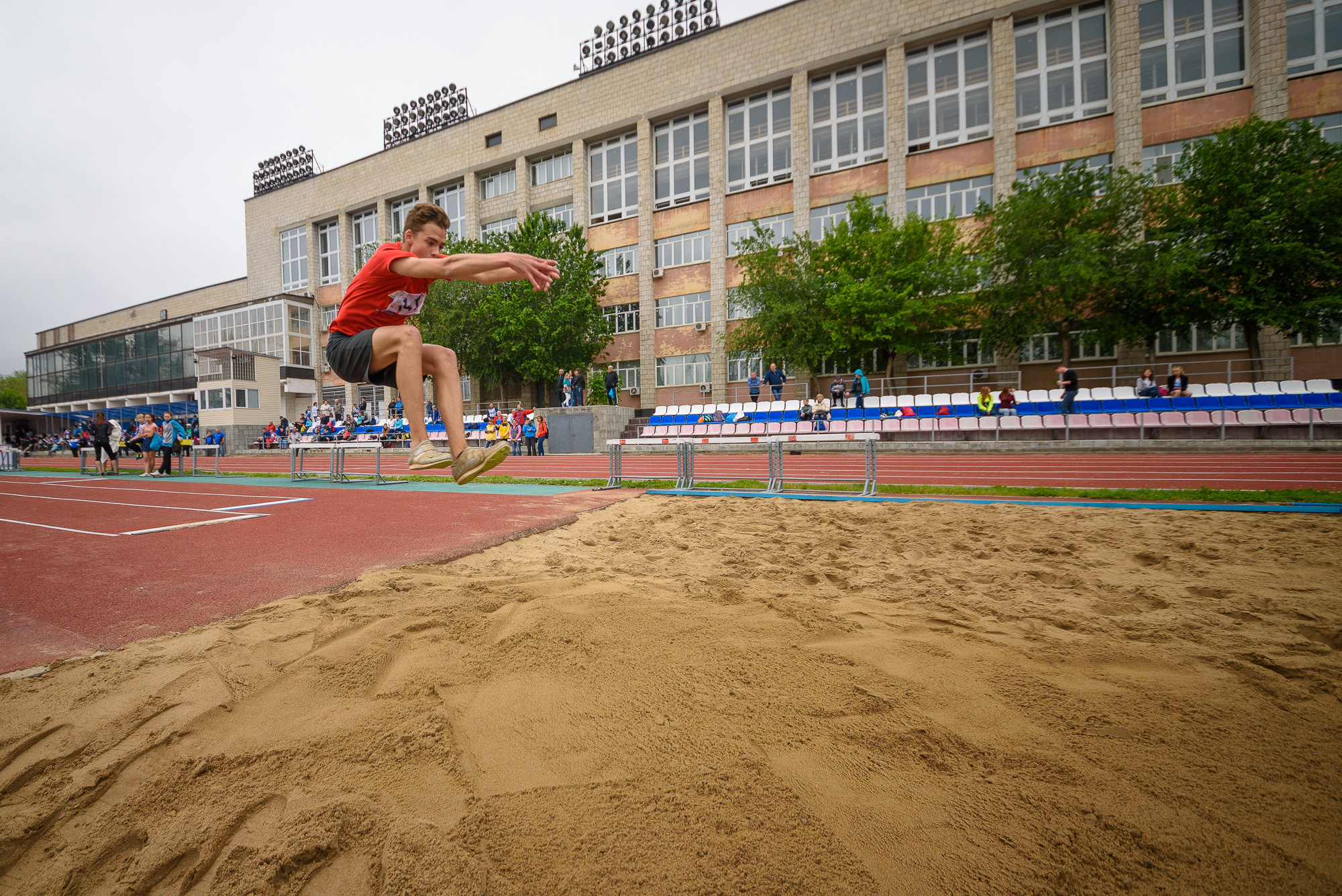 Спортсмен совершает тройной прыжок на соревнованиях