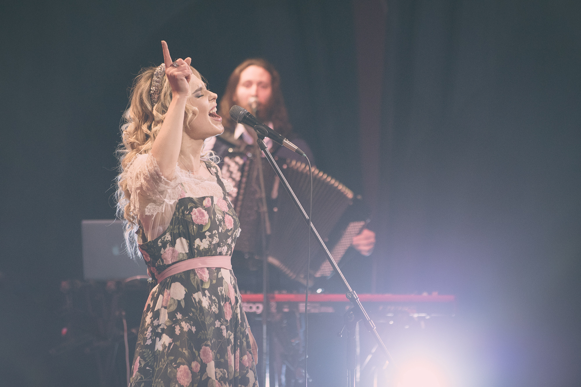 Пелагея эмоционально поёт песню на концерте, подняв палец вверх