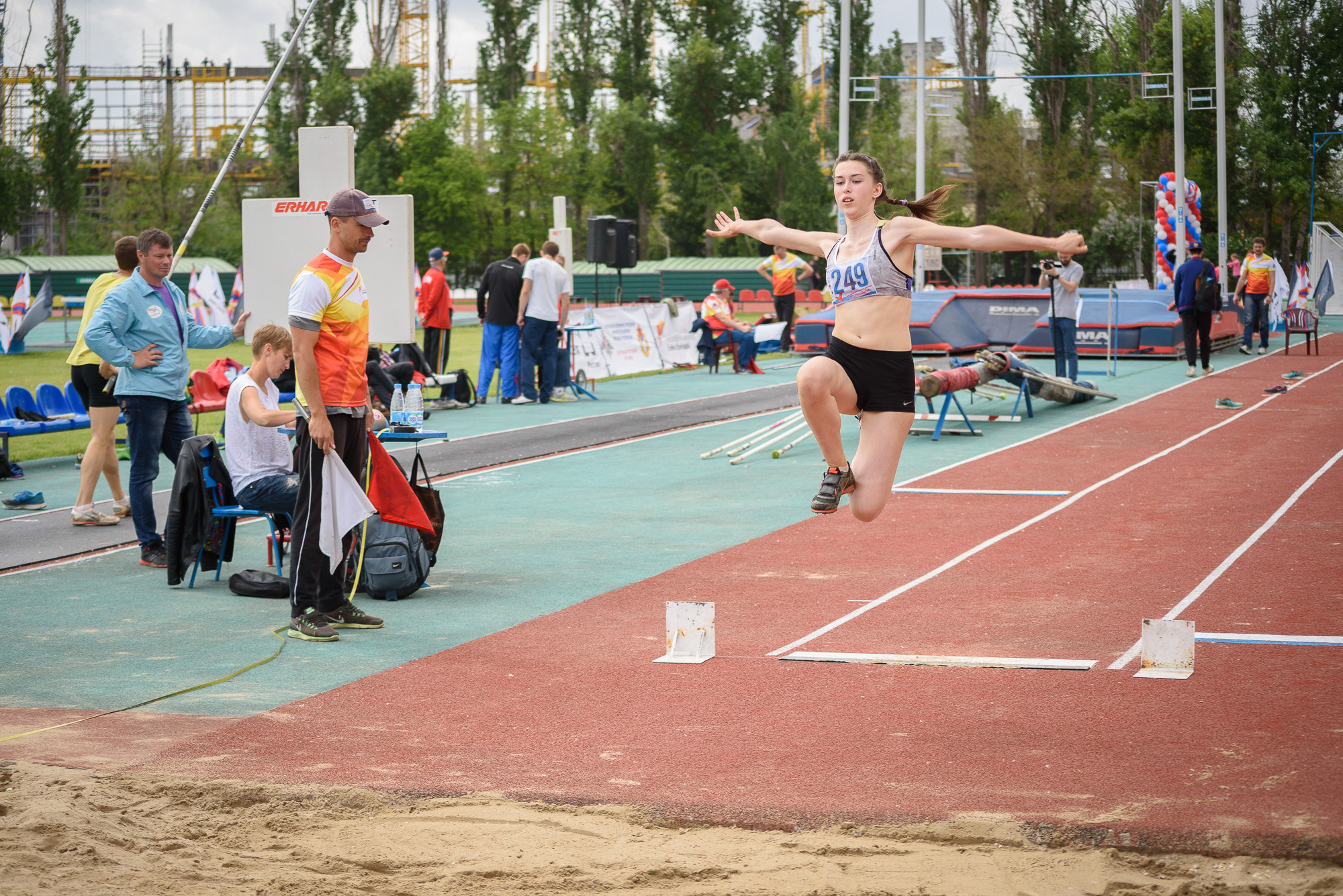 Прыгунья в полете во время совершения прыжка в длину