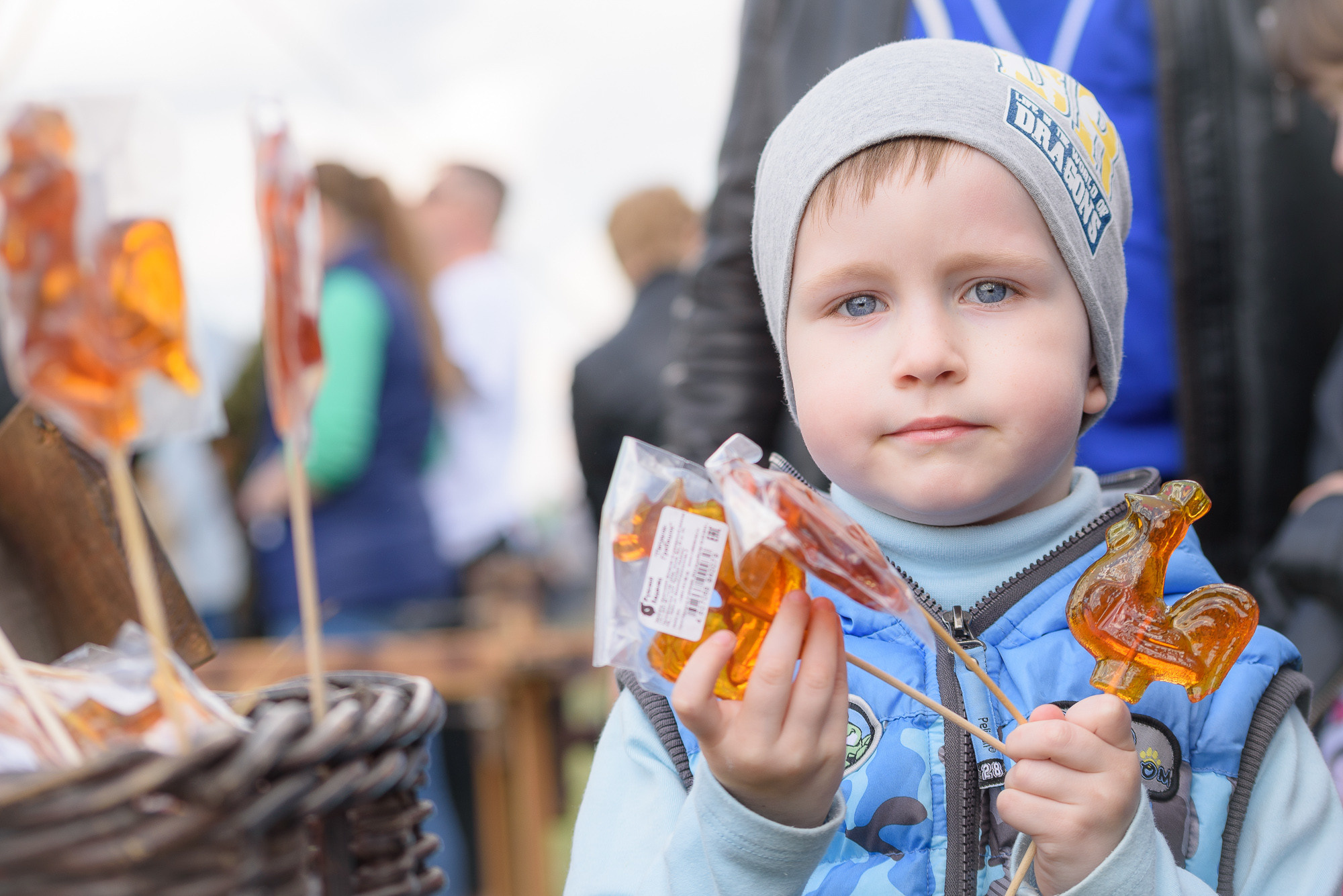 Ребенок с петушками на палочке