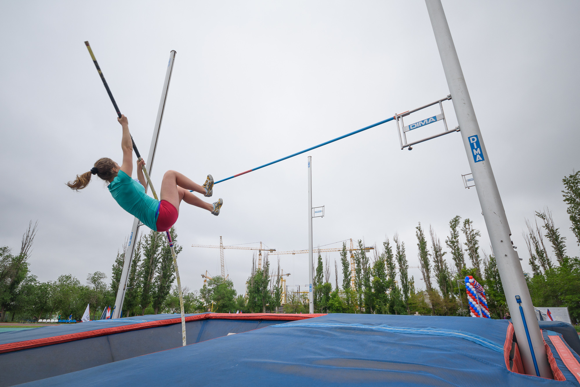 Прыгунья с шестом перелетает планку