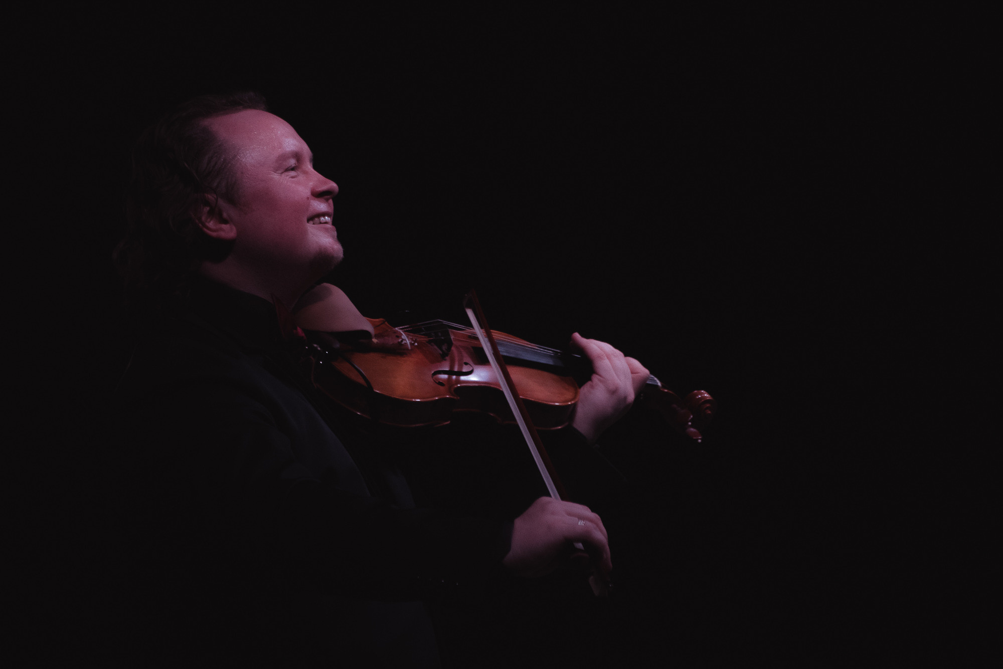 Мужчина играет на скрипке во время концерта