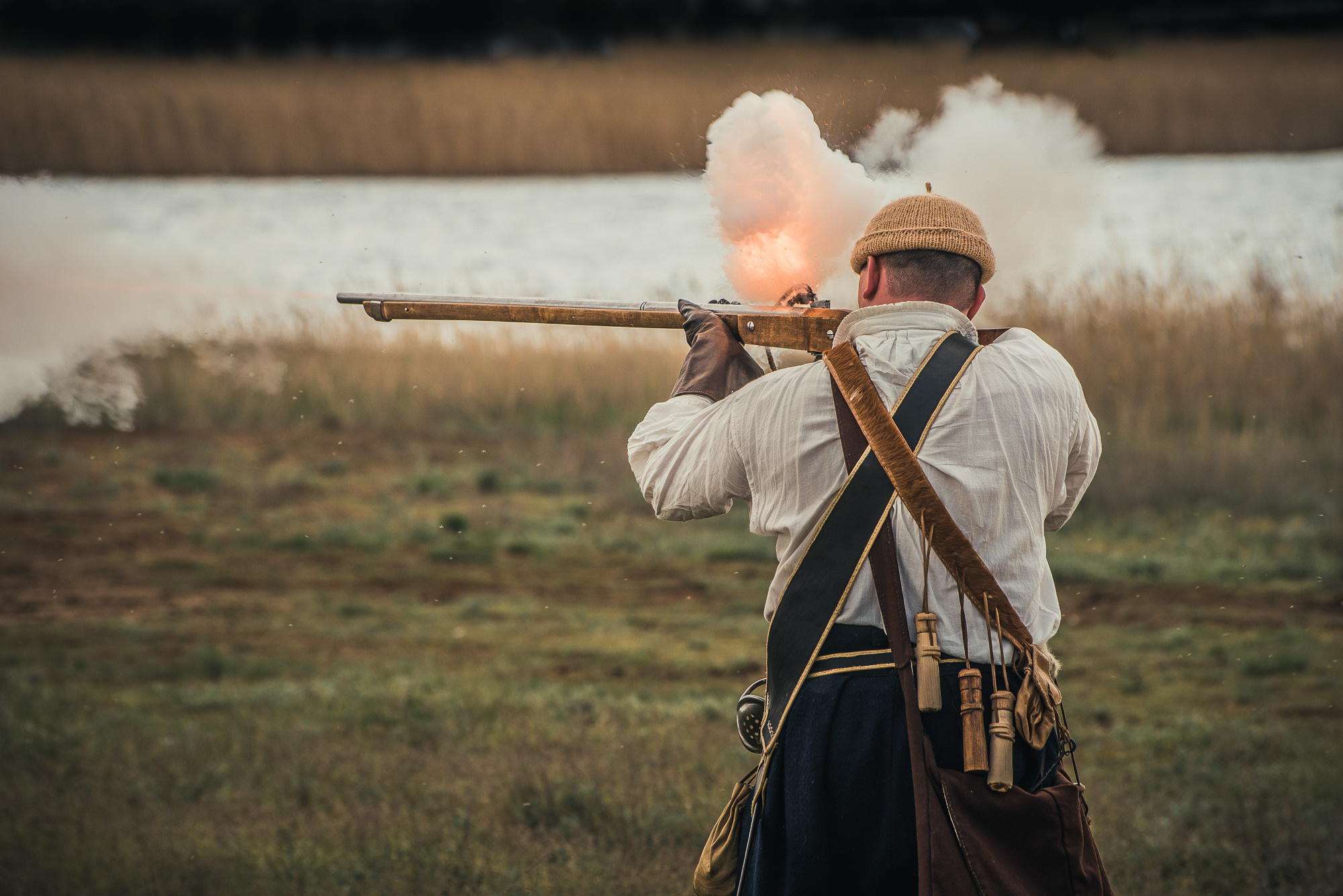 Мужчина стреляет из старинного орудия