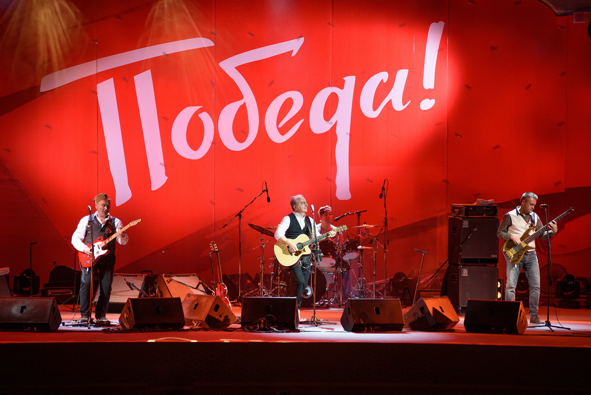 Группа Чайф на сцене с надписью "Победа!"