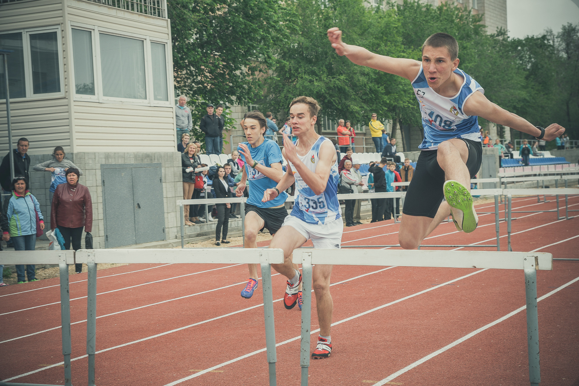 Спортсмен перепрыгивает барьер во время забега с препятствиями