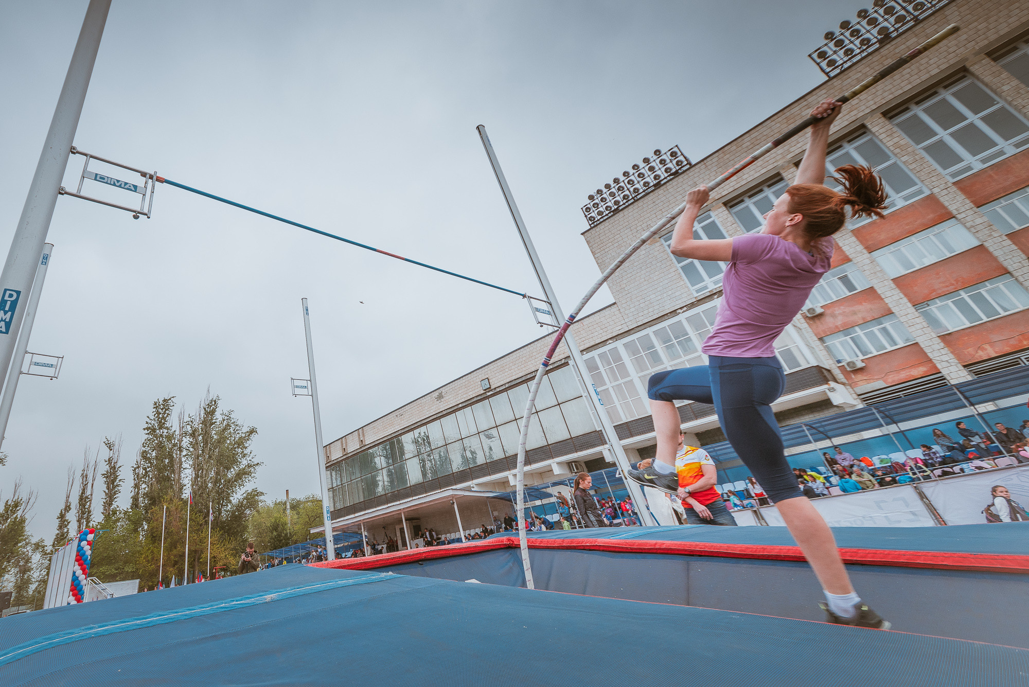 Девушка с шестом взлетает вверх