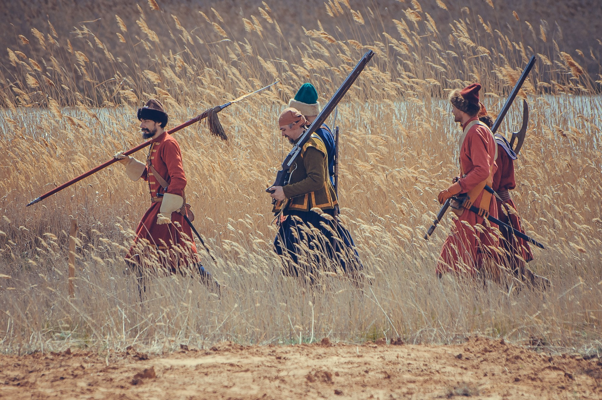 Реконструкторы идут по зарослям камыша