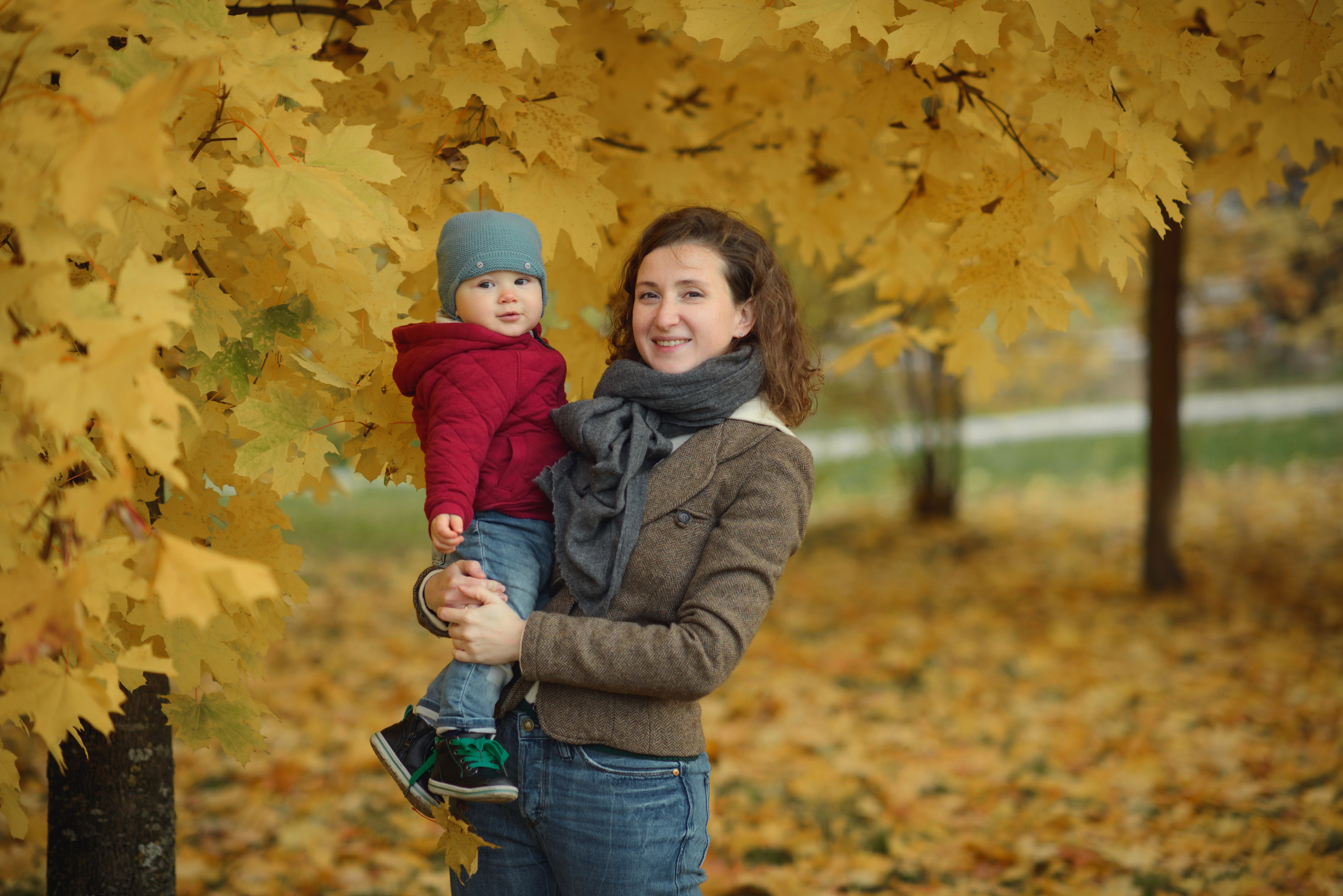 Photo shoot of a mom with baby in autumn. Photos with yellow leaves
