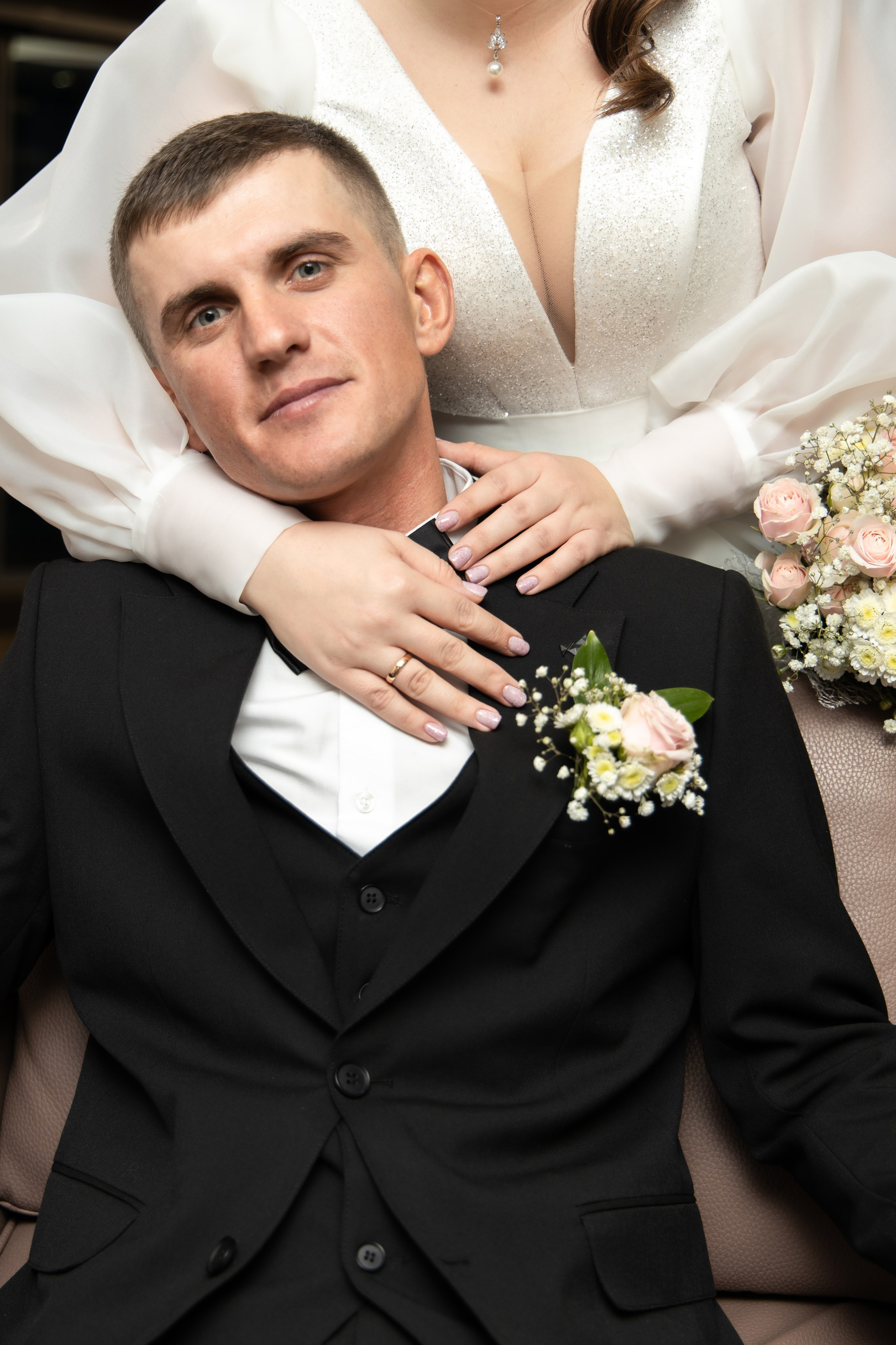 Жених сидит на стуле. его за шею обнимает невеста. Свадебная фотосессия Астрахань.