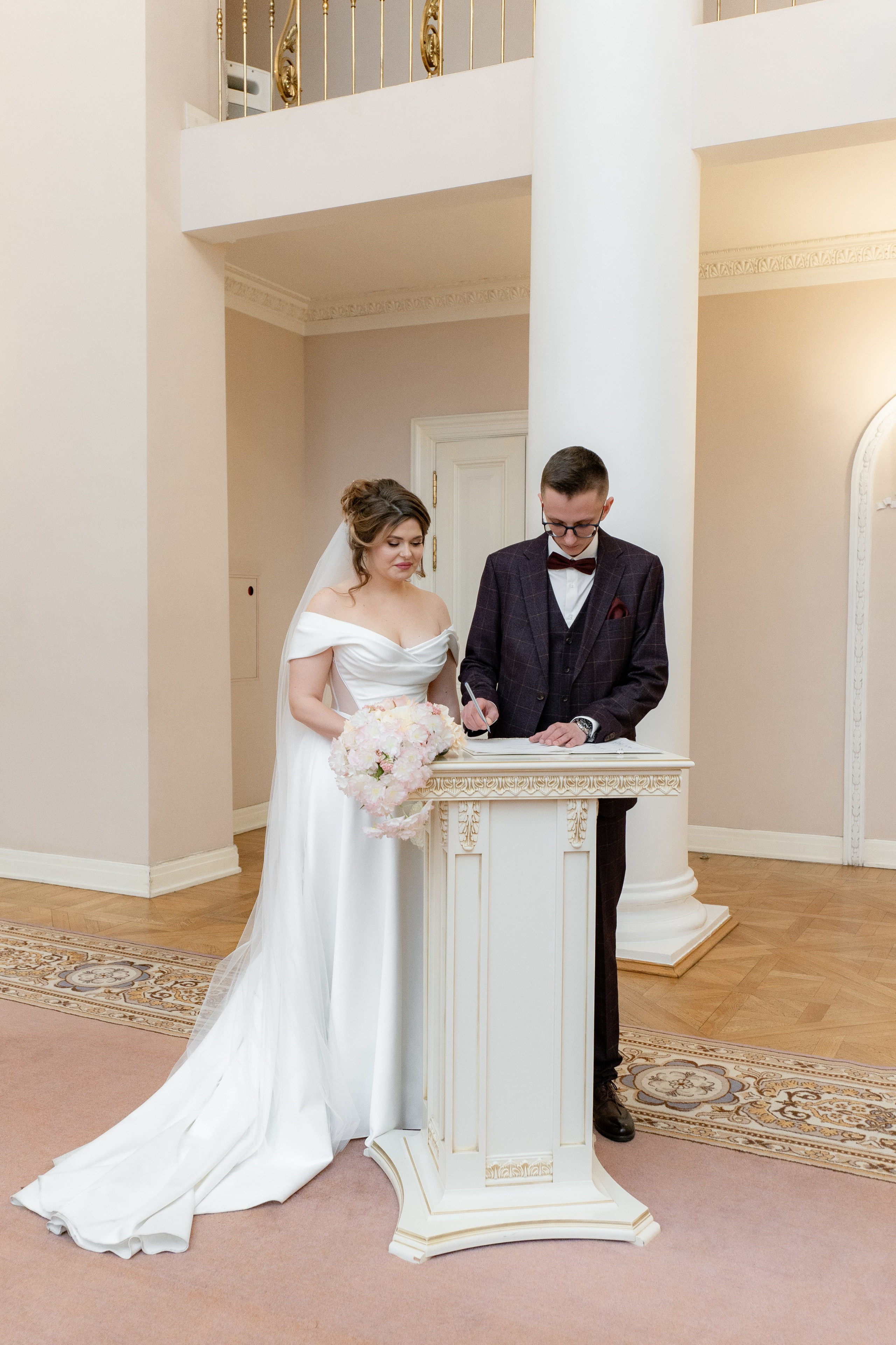 Жених и невеста ставят подписи во Дворце бракосочетания в Царском Селе.