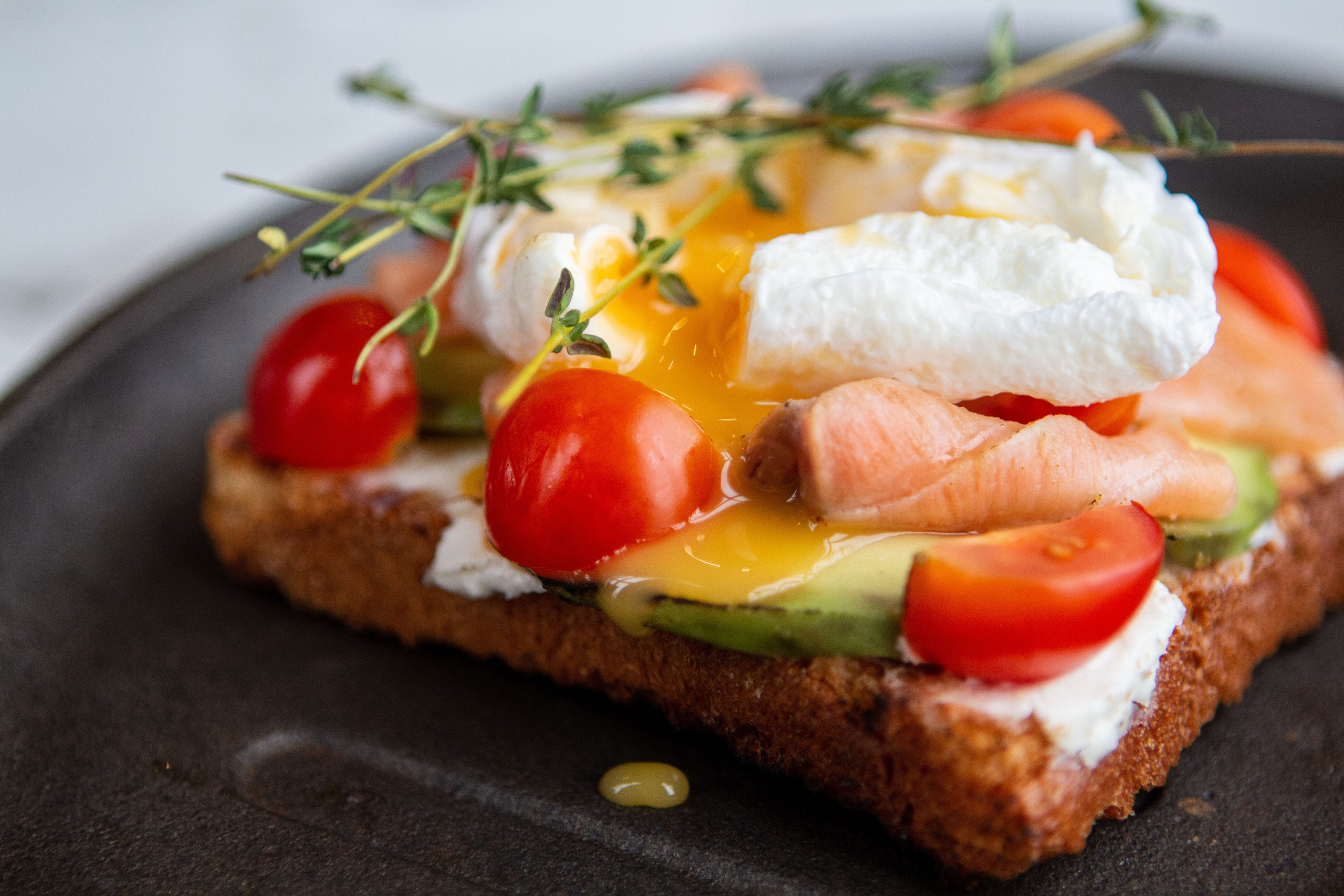 Слабосоленый подкопченный лосось, свежее авокадо, томаты черри, яйцо пашот на хрустящем тосте белого хлеба · 200 г