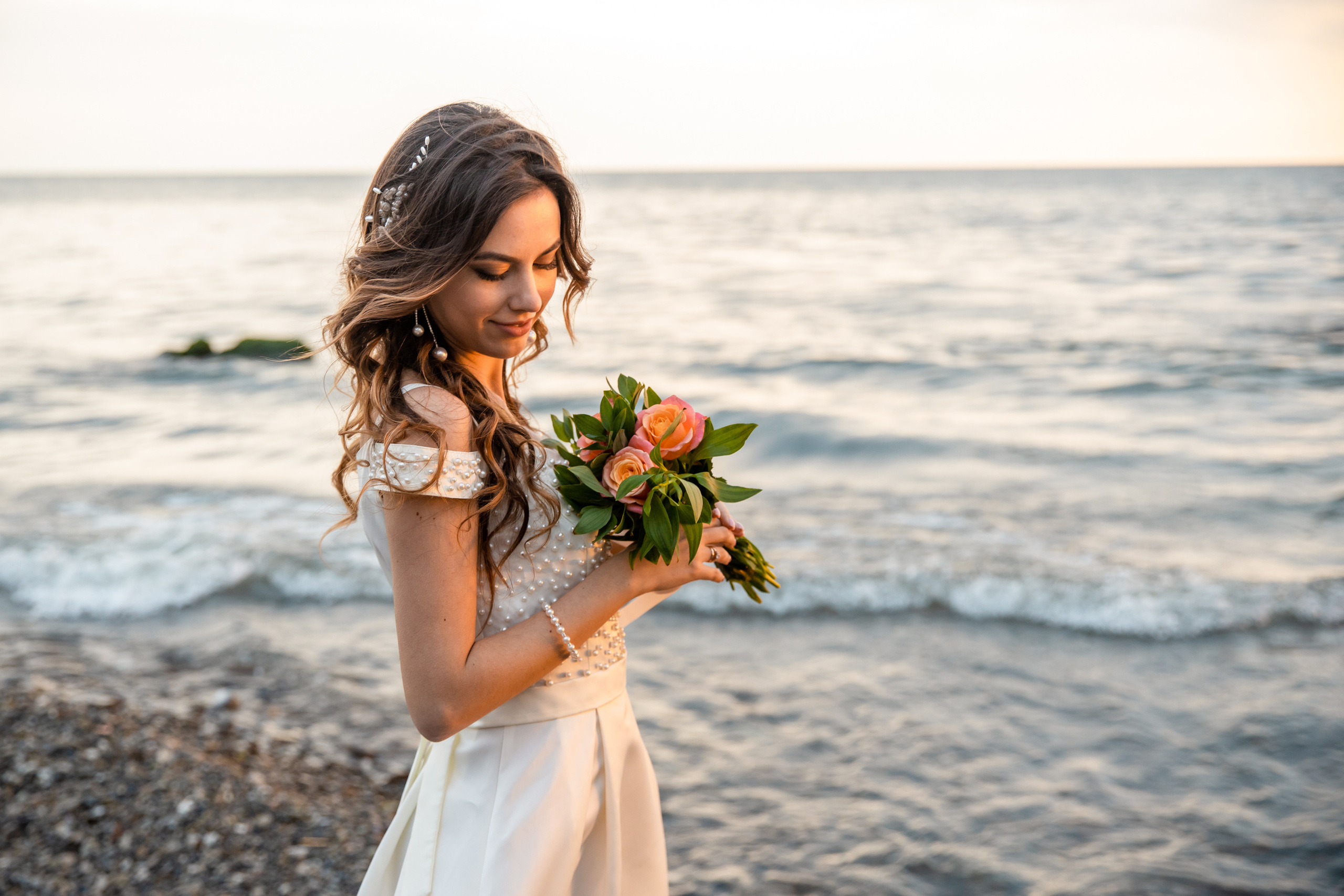 Красивая невеста с букетом на закате