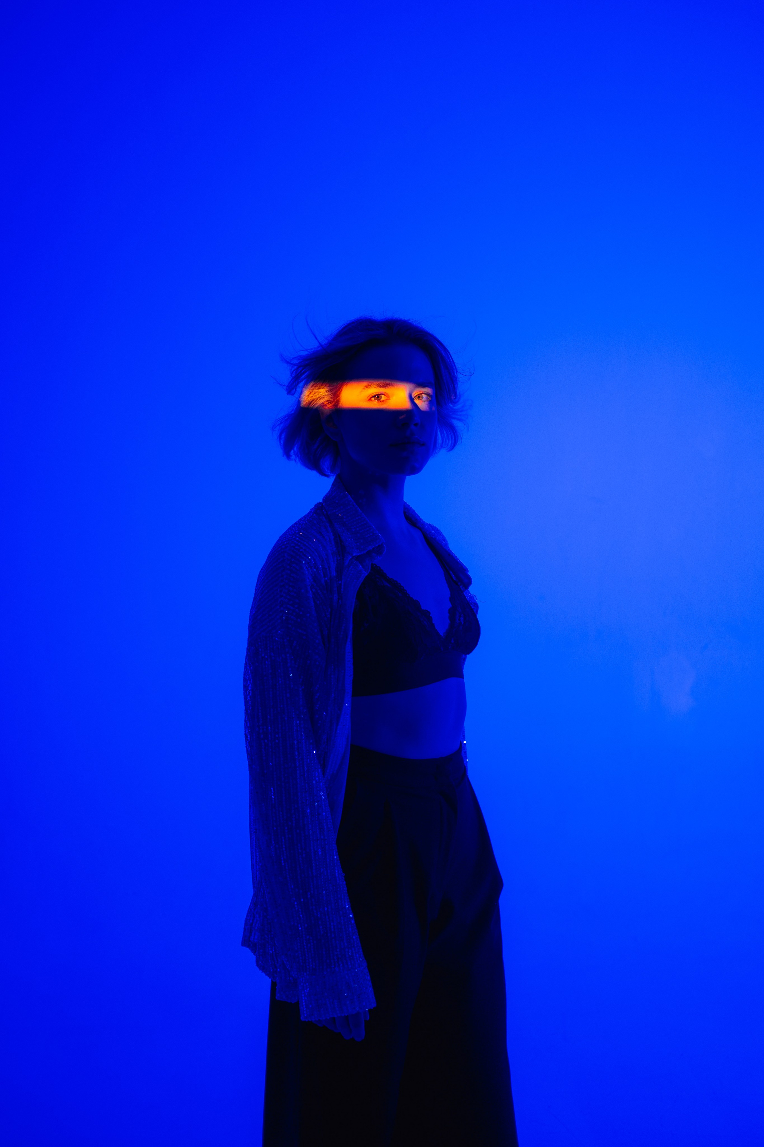 Девушка на синем фоне с полосой света на глазах