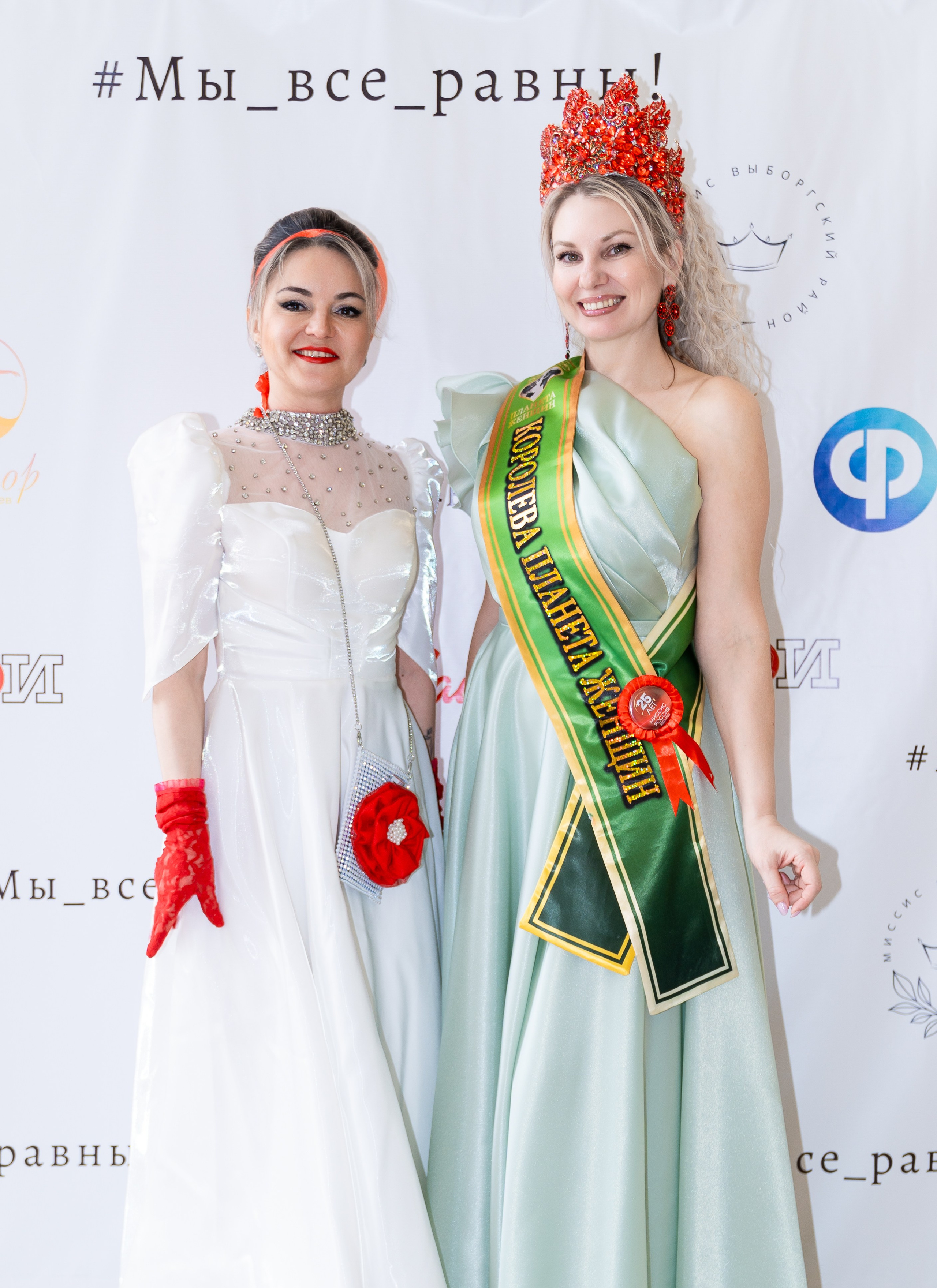 Бал Все Равны. Две участницы : «Королева планеты женщин» в зелёном платье с короной и участница в белом платье. Фотография с бала Мы все Равны. Автор: Евгений Мальцев (evrednix.ru).