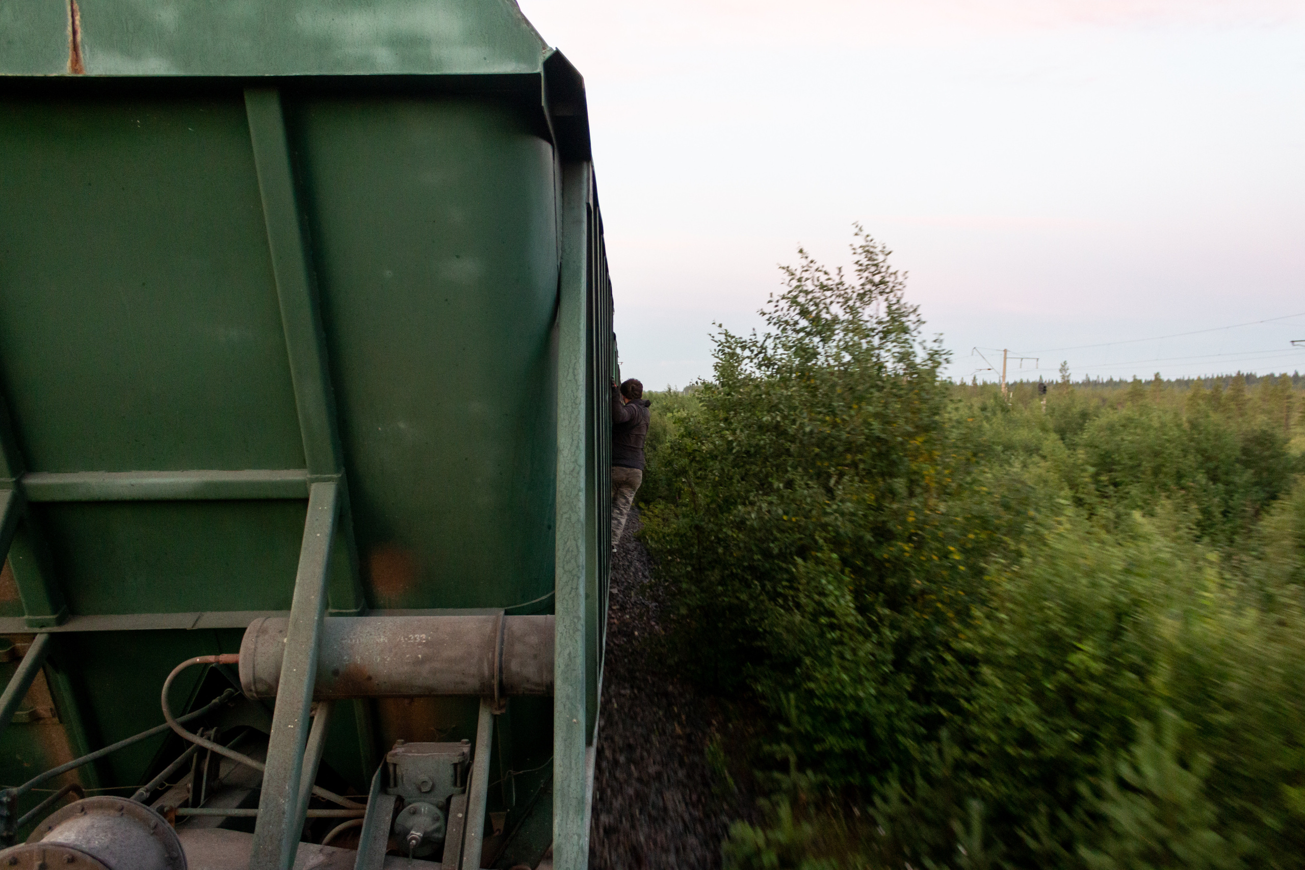 Danya climbing along the hopper wagon wall to warn his friends that they have to leave the train on the upcoming stop.