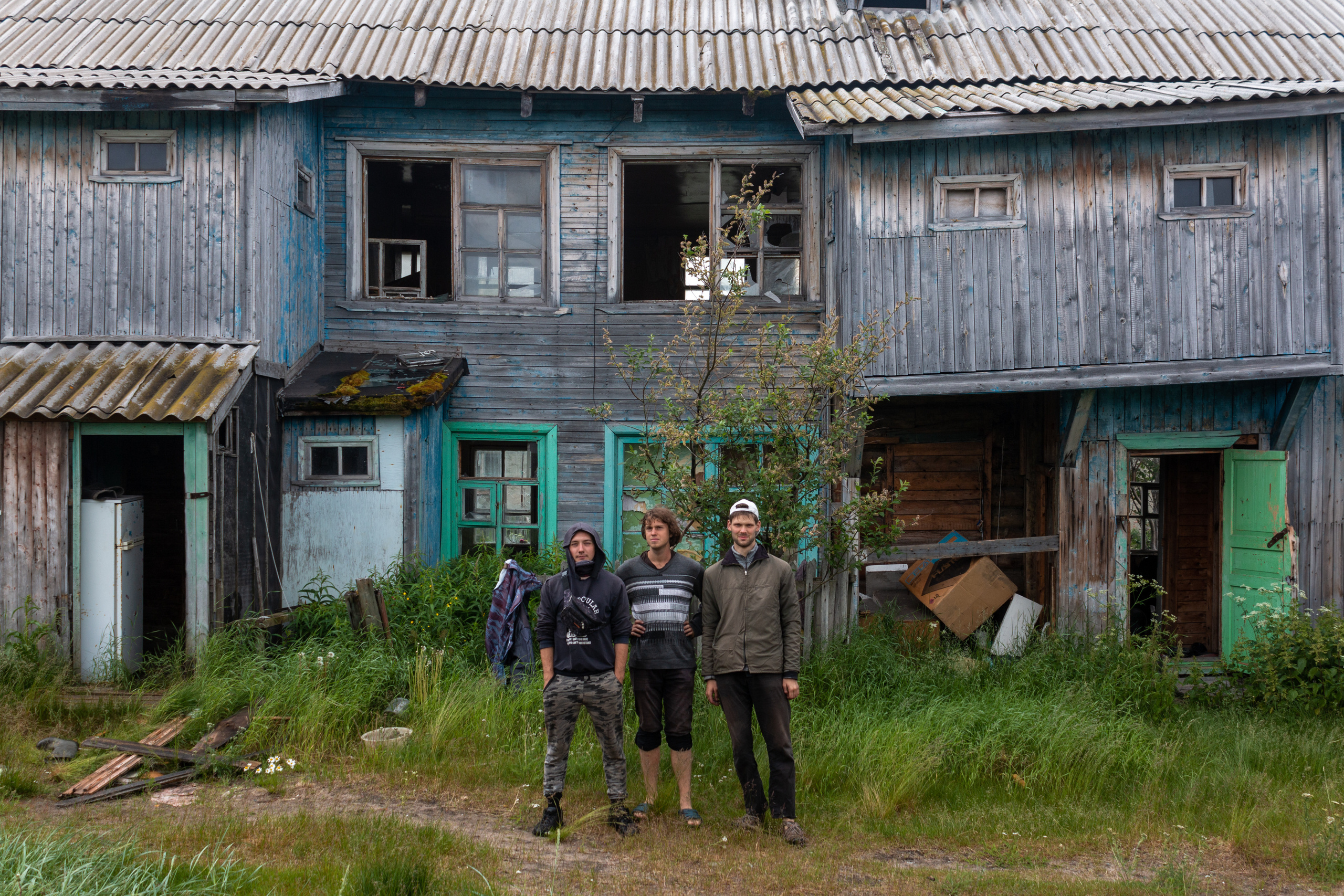 Edik, Roma and Danya posing in front of the abandoned house they have just spent the night in.