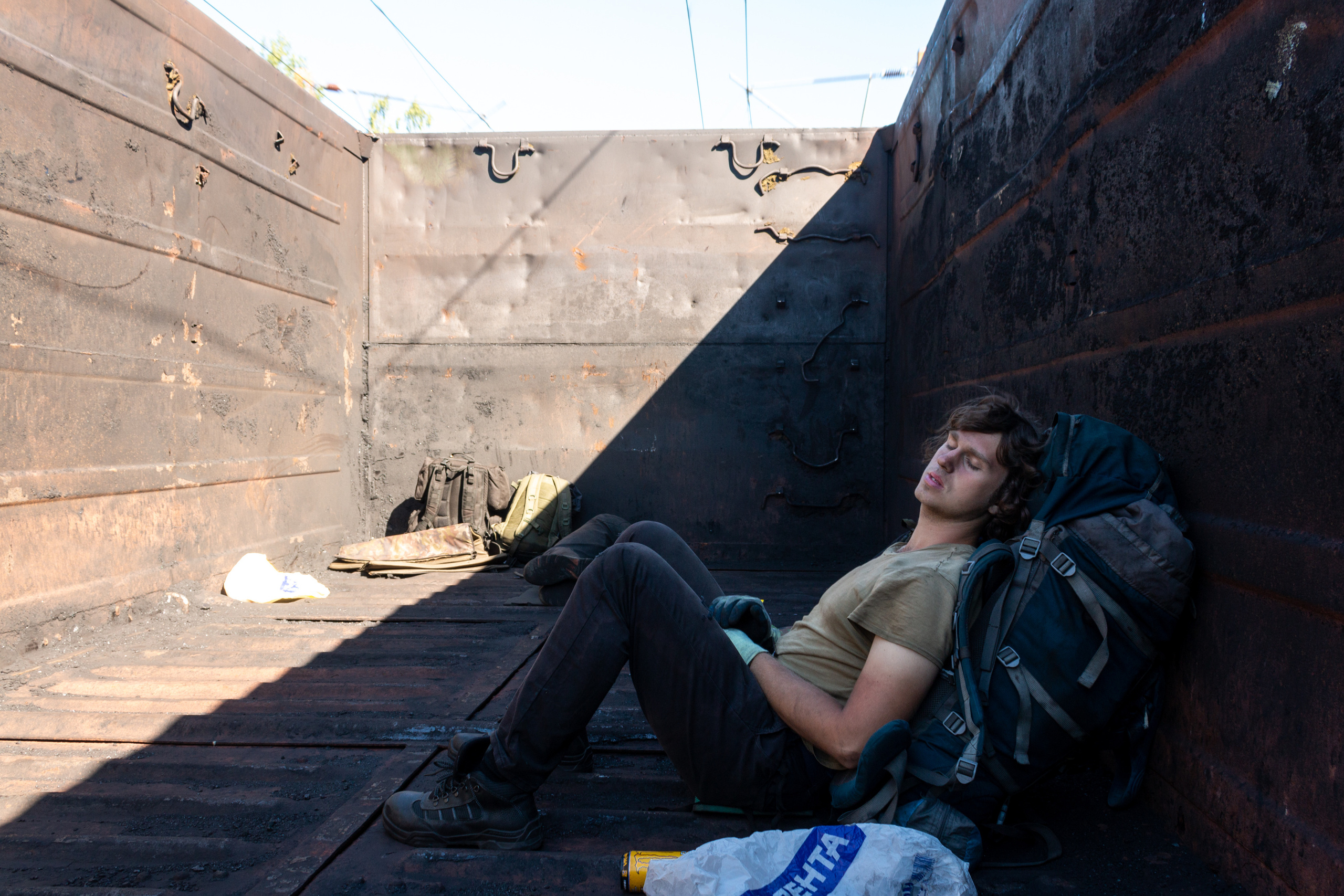 Edik sleeping on his backpack in an empty open wagon on the way to Murmansk.