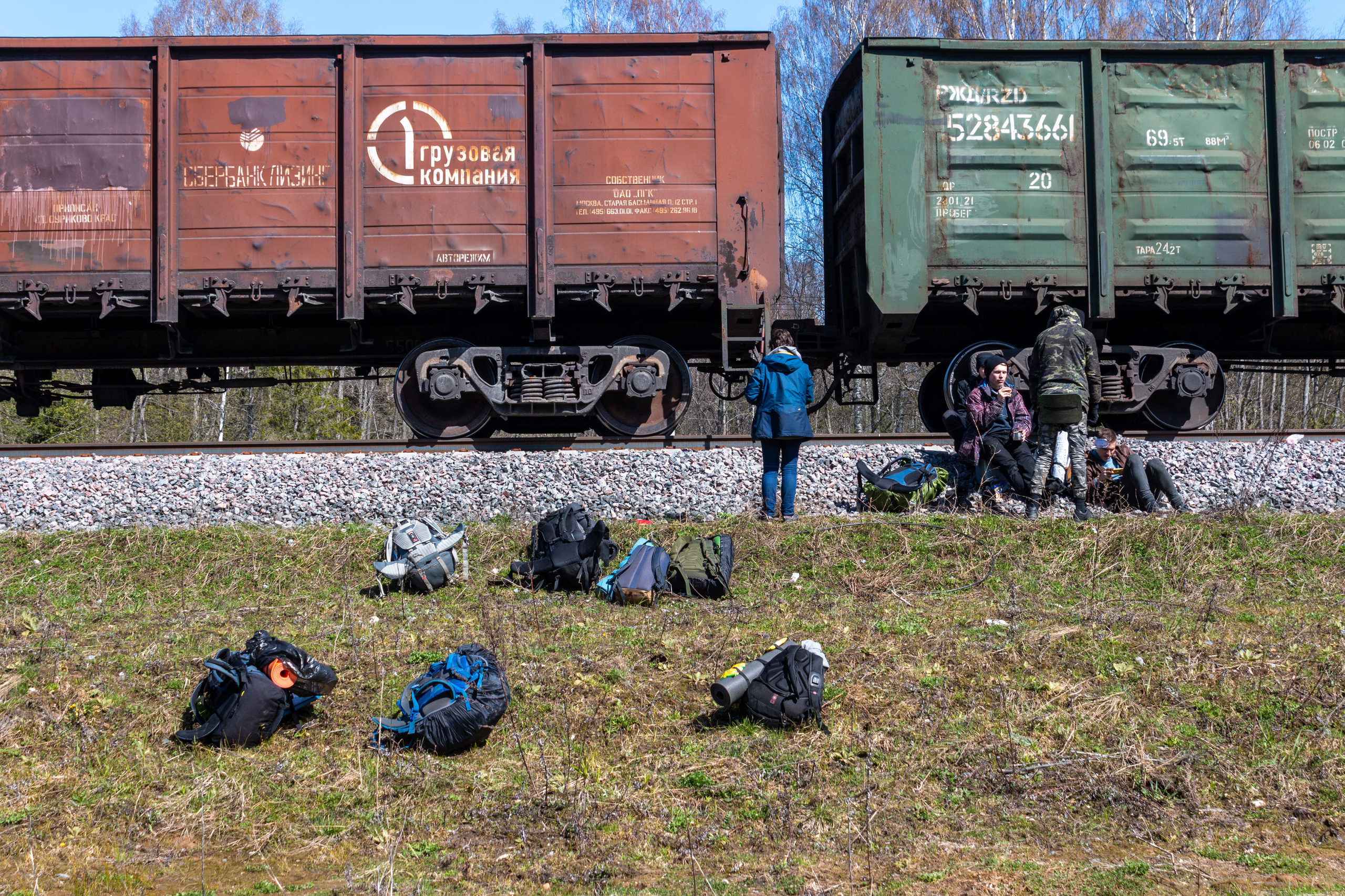 The guys chilling beside the train which stopped on the track because of the overcrowded arrival station.