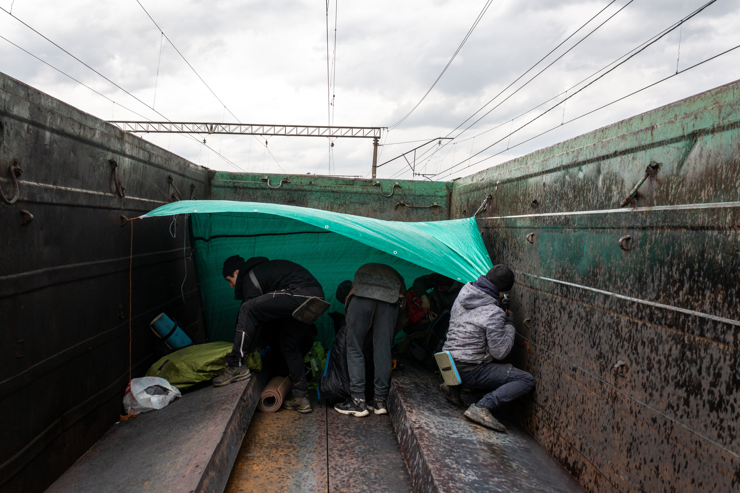 The guys are setting up the tent to hide from the upcoming downpoor.