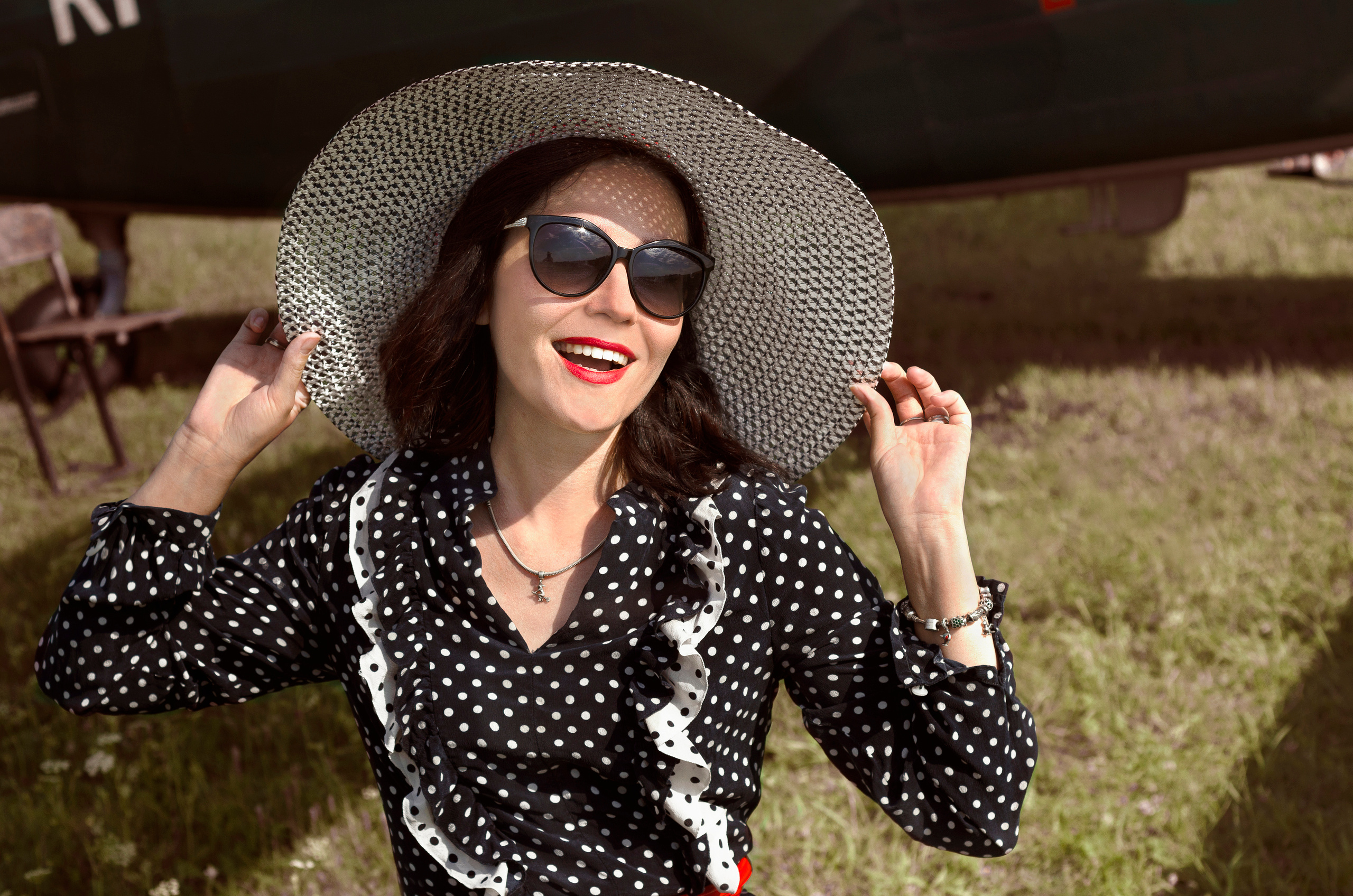 Девушка в платье в горошек, в большой белой шляпе.