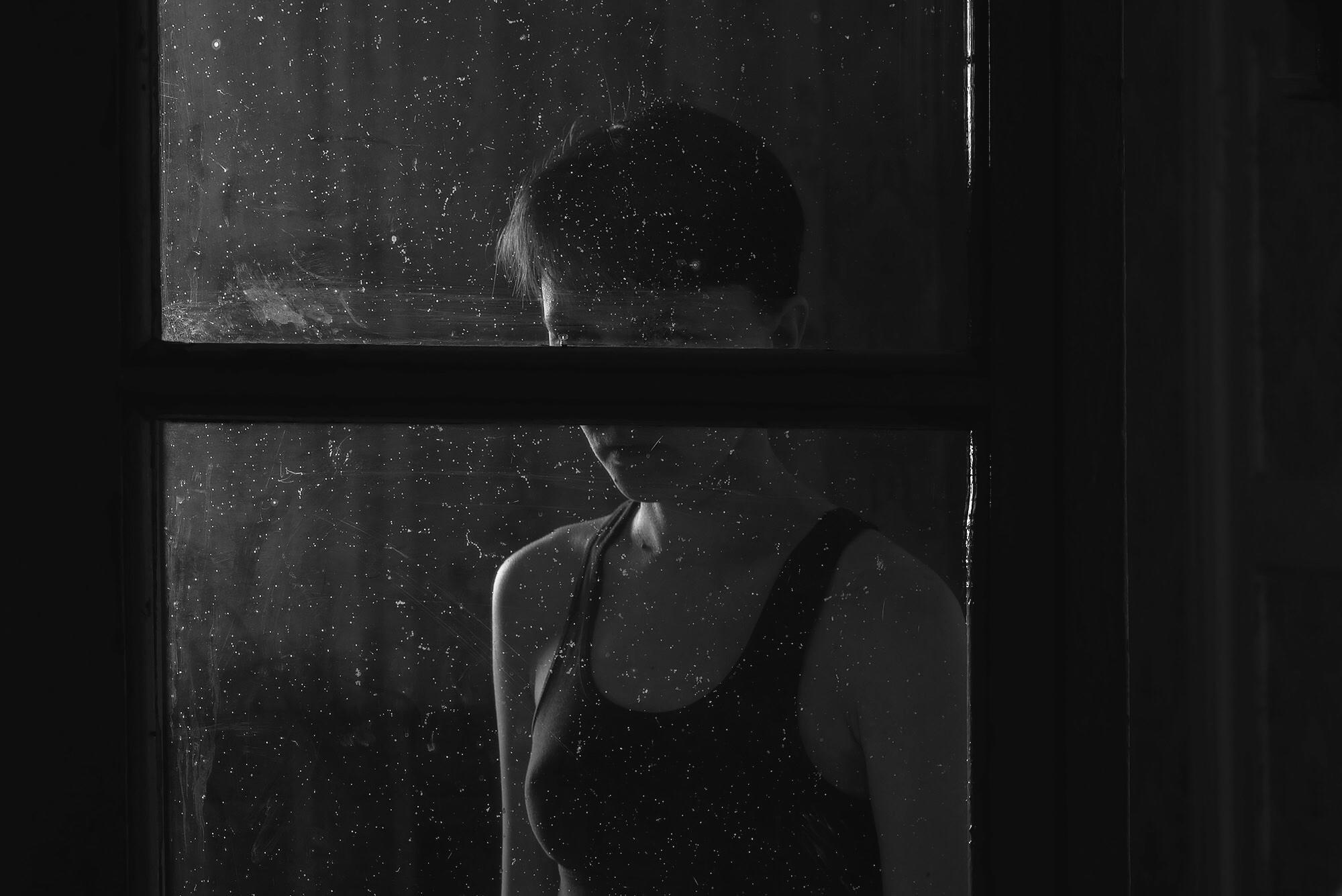 Черно-белая фотография девушки за дверью