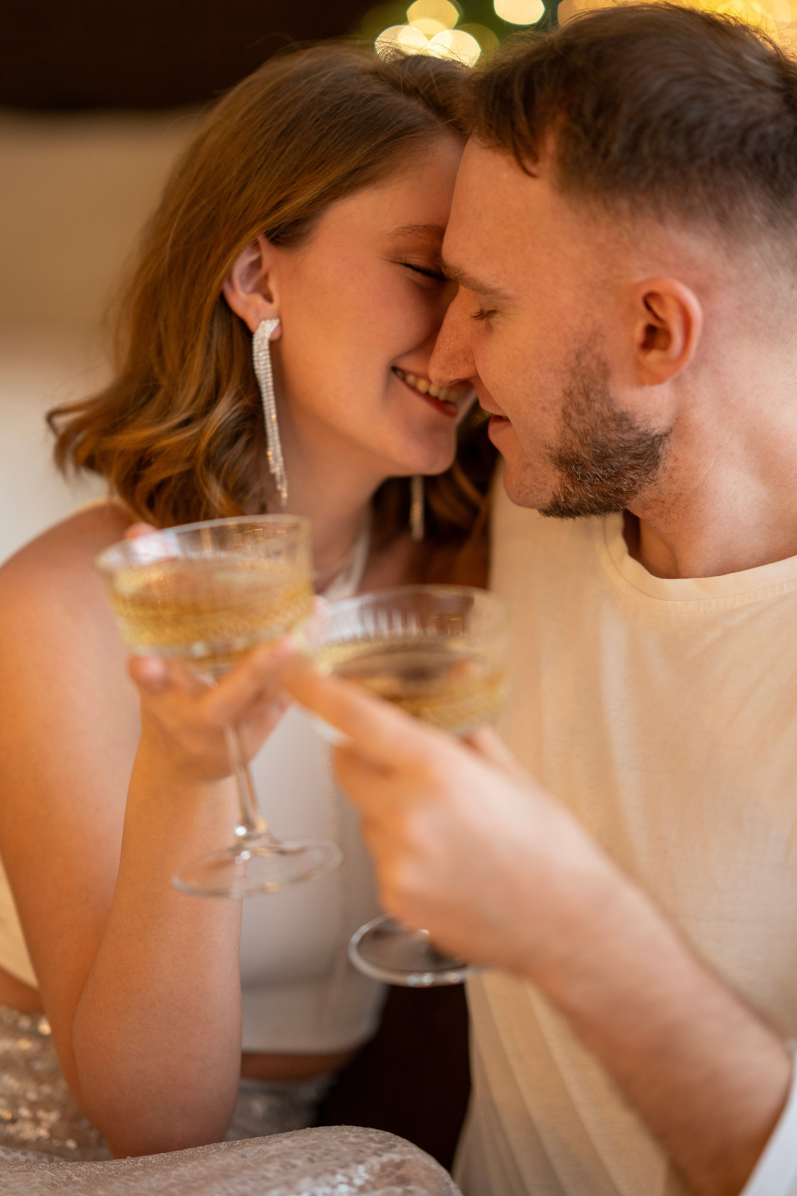 Пара молодых людей, парень и девушка, целуются с фужерами шампанского в руках