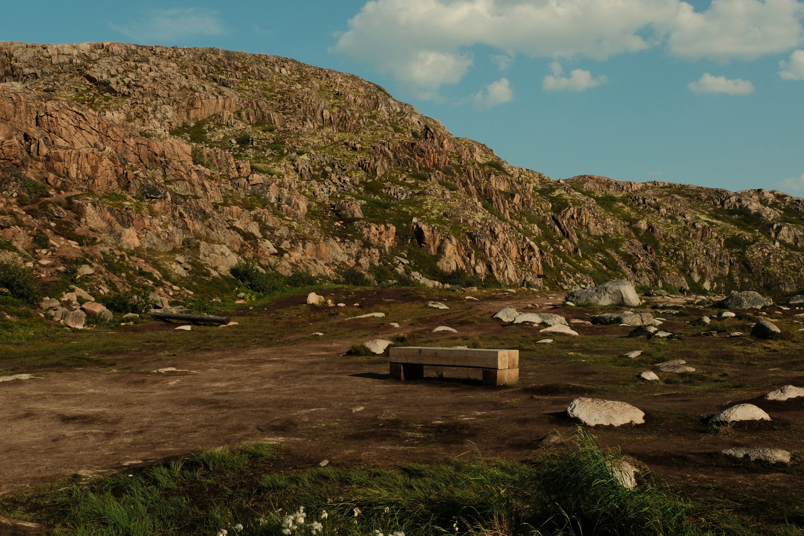 a wooden bench stands in the middle of a national natural park and mountains