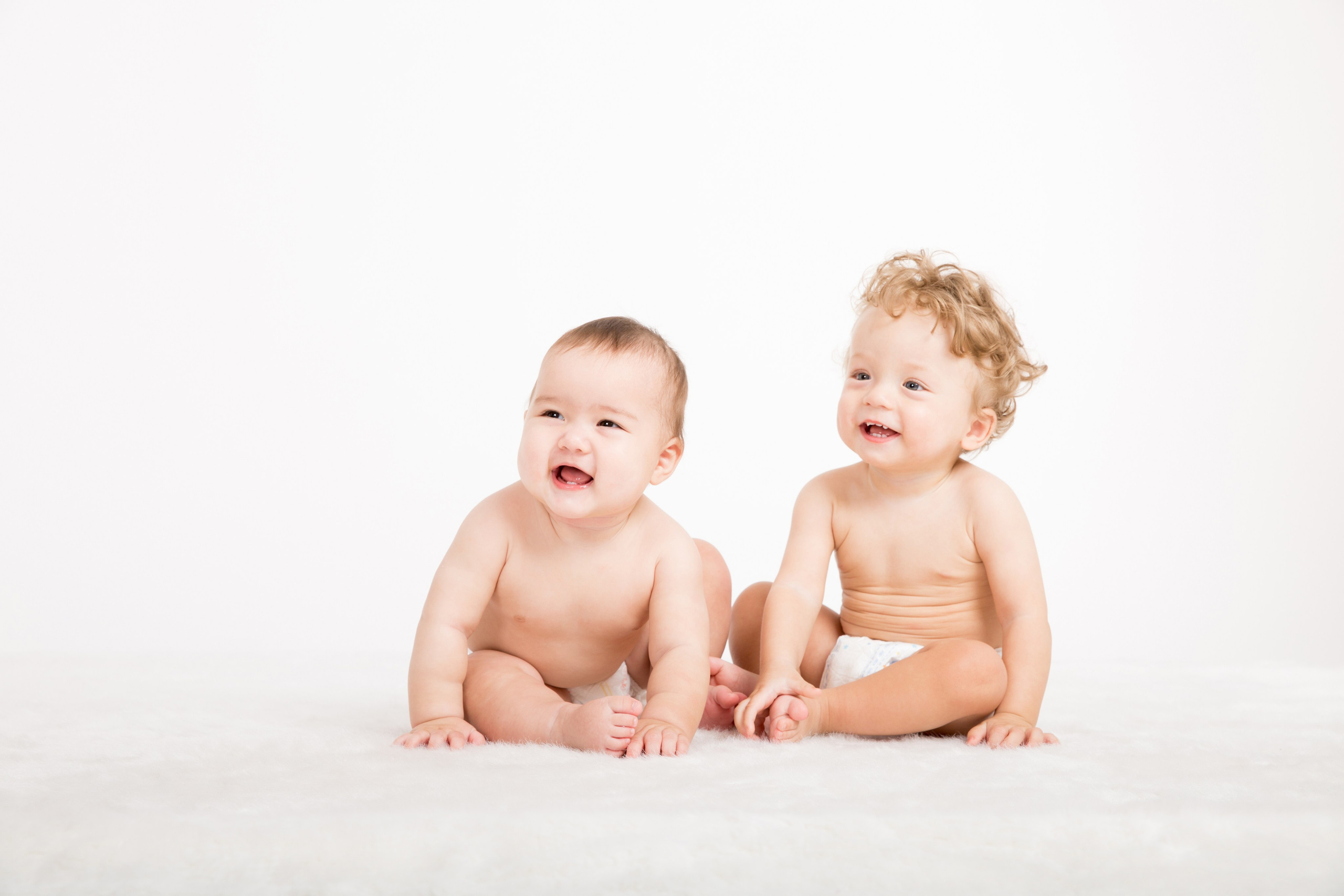 Два младенца на светлом фоне. Детская фотосессия Алматы.