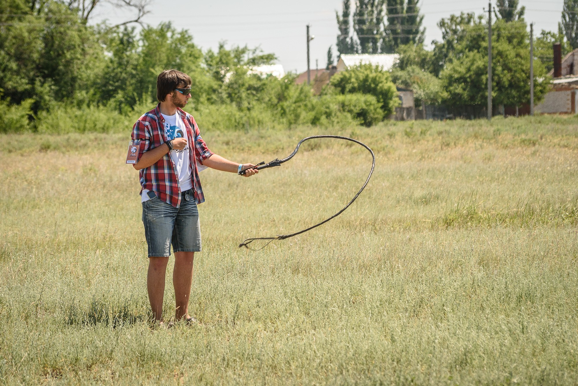 Парень в клетчатой рубашке тренируется с хлыстом