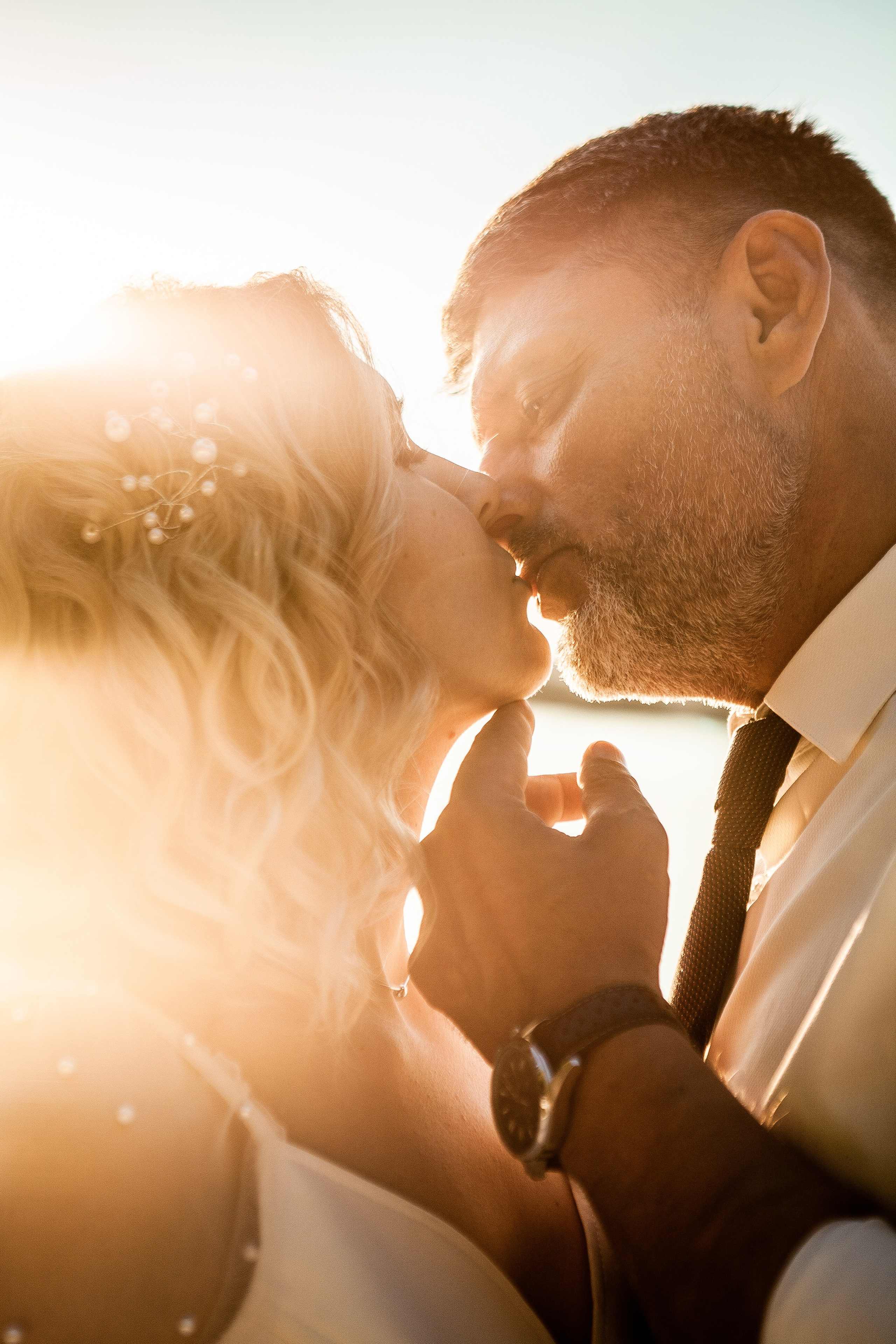 Страстный поцелуй жениха и невесты на закате, крупный портрет влюбленных